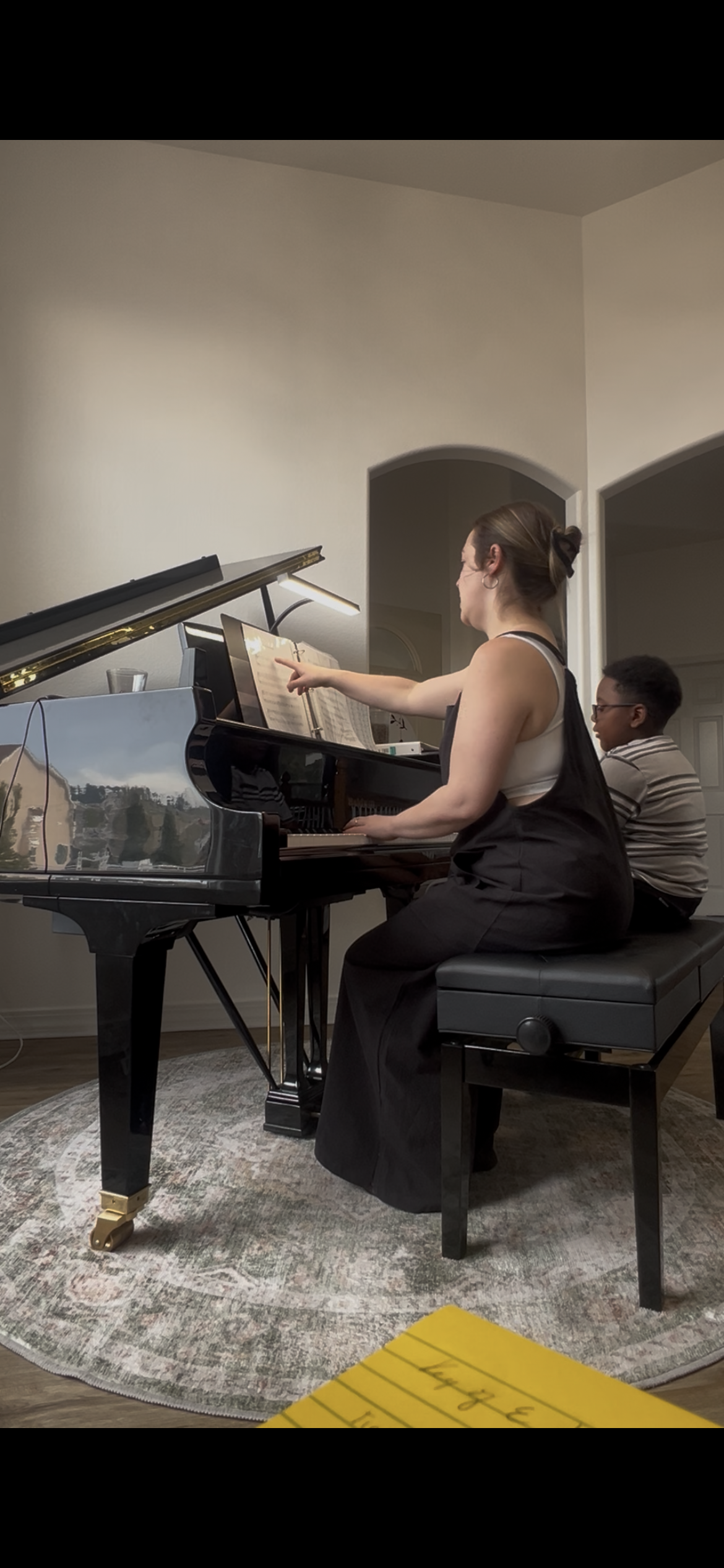Brittany Brown guiding a student through music reading and piano exploration during a private lesson.