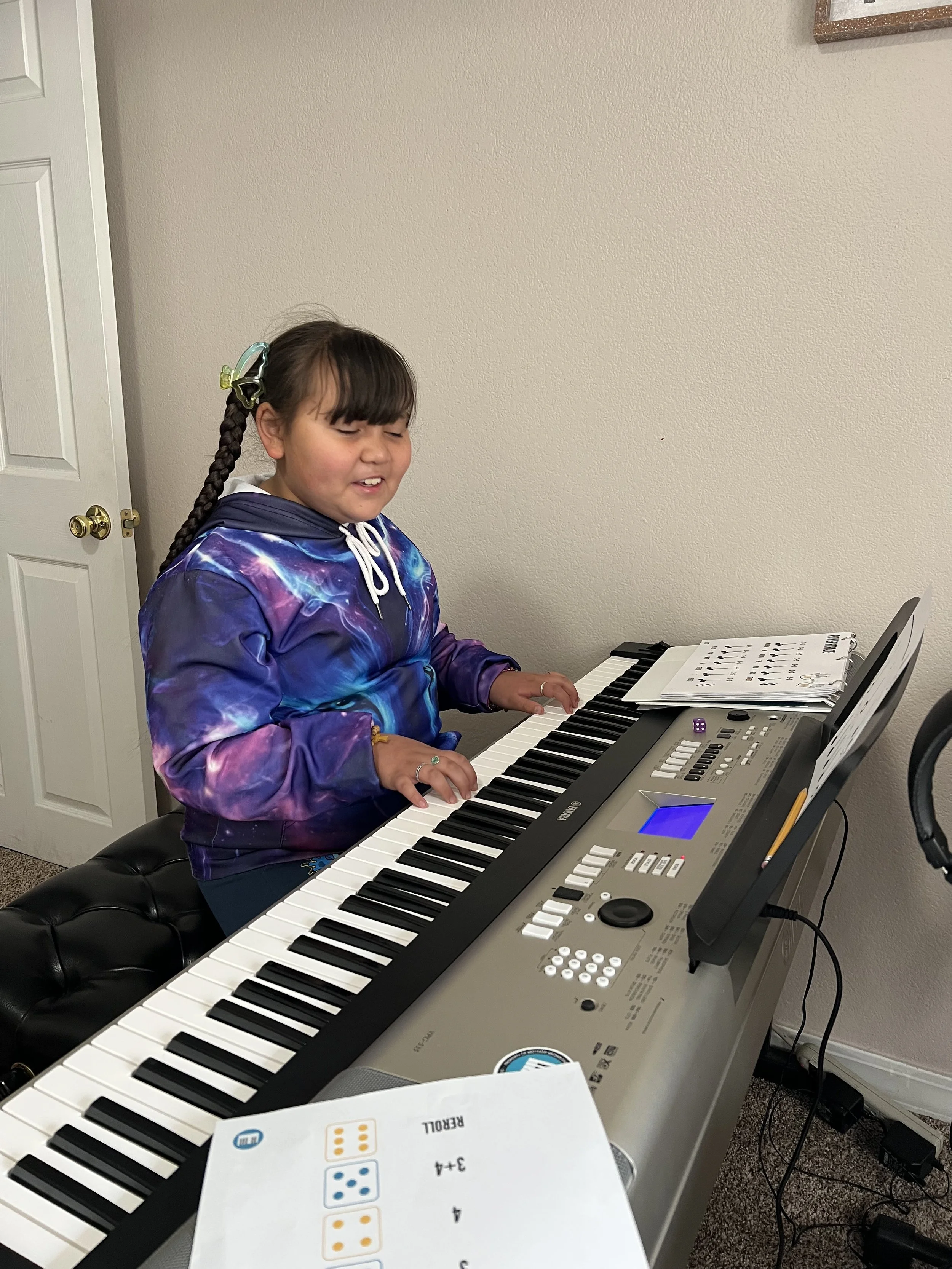Young piano student practicing on an electronic keyboard during a music lesson.