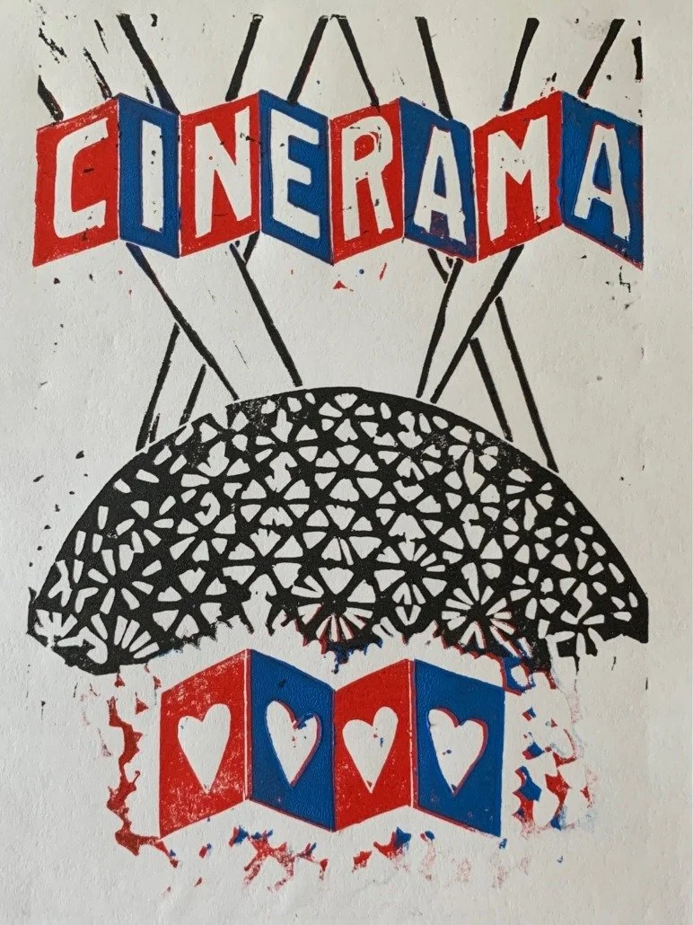 Stencil art depicting a hot air balloon with the word "CINERAMA" on the balloons, and a basket made of blocks with heart cutouts. The design uses black, red, and blue colors.