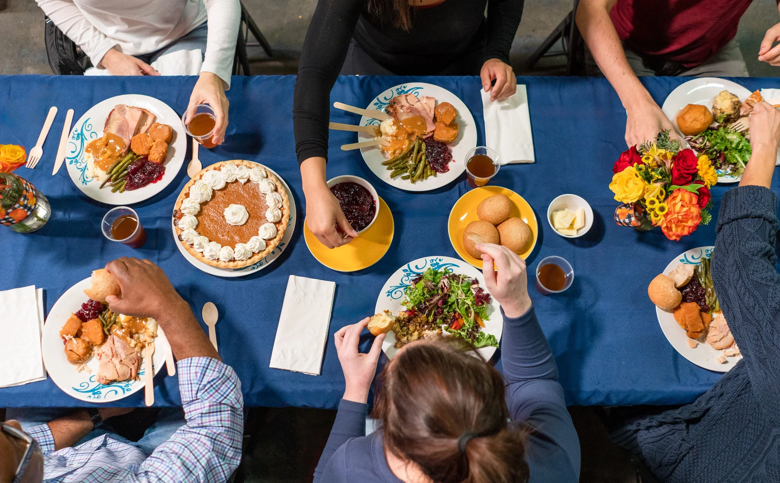 Group of people gathered around a table filled with food