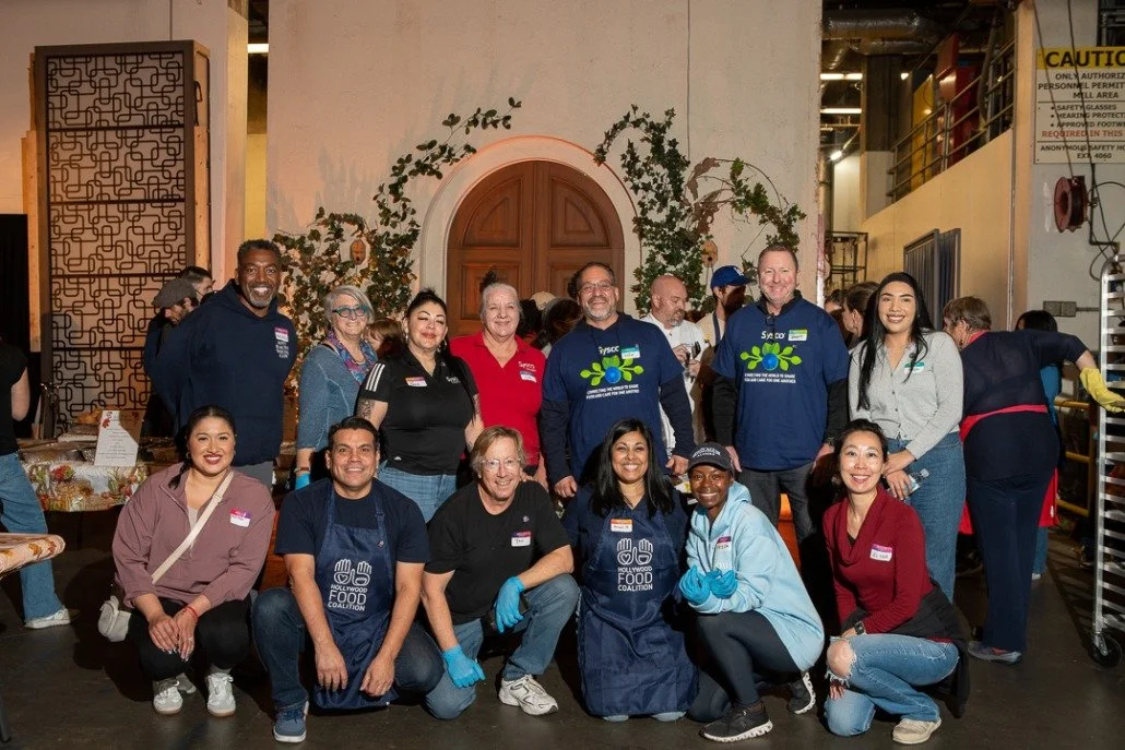 Group of diverse people posing inside at a community event or volunteer activity.