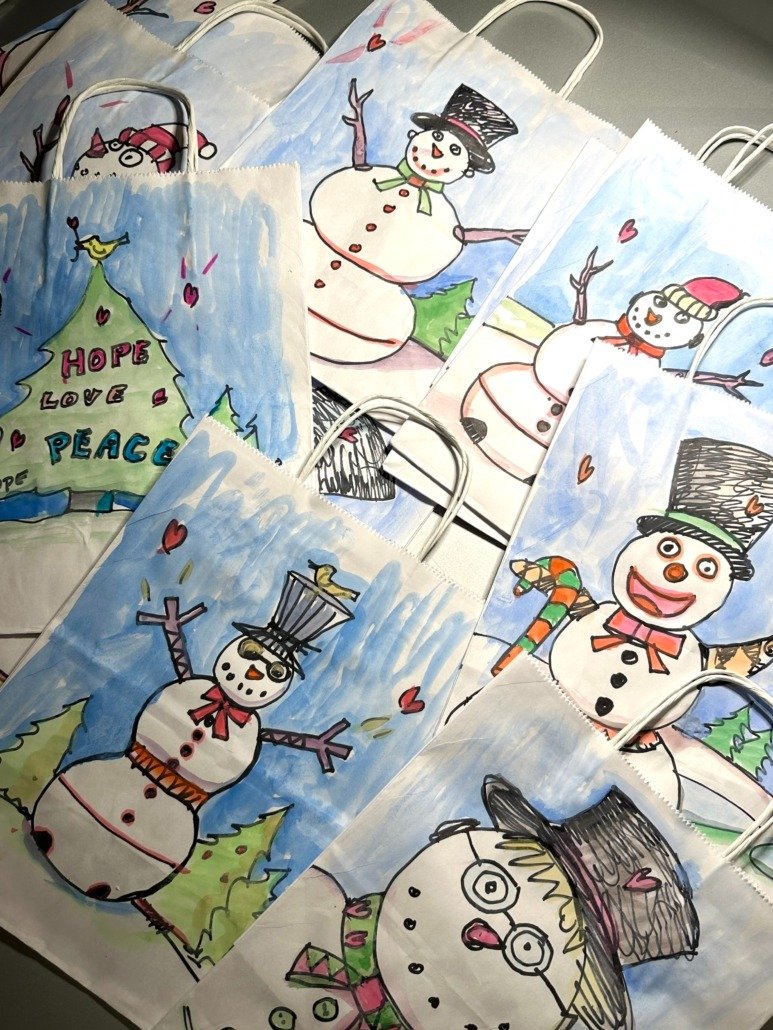 Collection of hand-drawn Christmas-themed bags featuring snowmen and holiday messages.