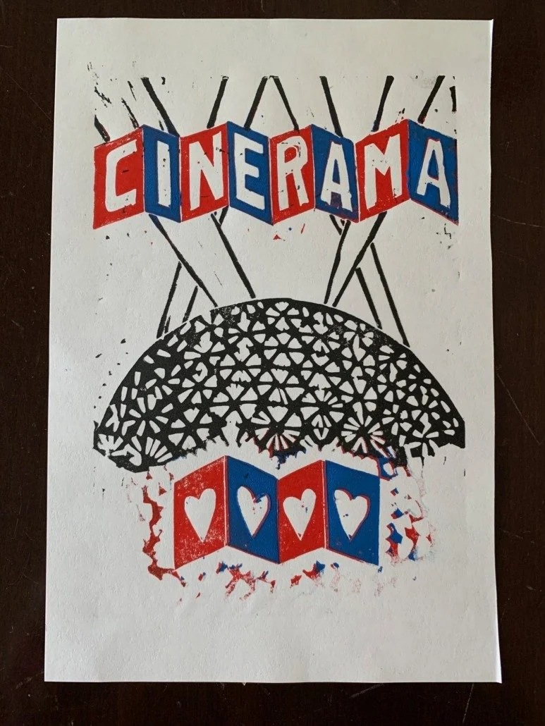 A black and white spinning top with a geometric pattern, with the word "CINERAMA" in colorful, block letters above it and a row of four blocks with hearts below.