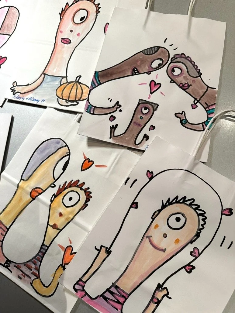 Collection of children's drawings of cartoonish, anthropomorphic characters with elongated faces, large eyes, and expressive features, some surrounded by hearts.