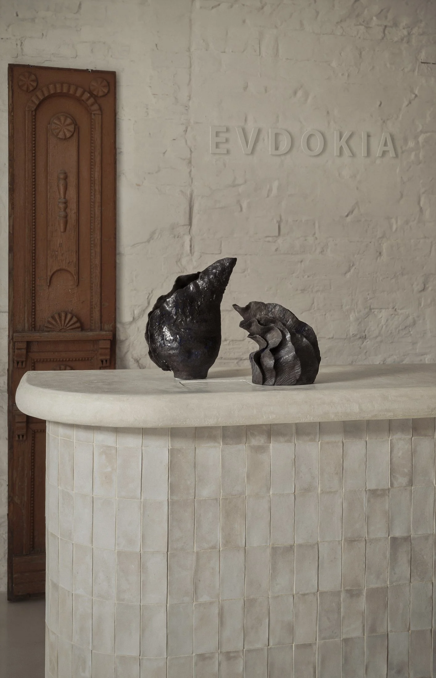 Reception area interior design of Evdokia Brand Store by Jenny Ly Studio — hand-tiled counter in soft white tones with sculptural ceramic accents.