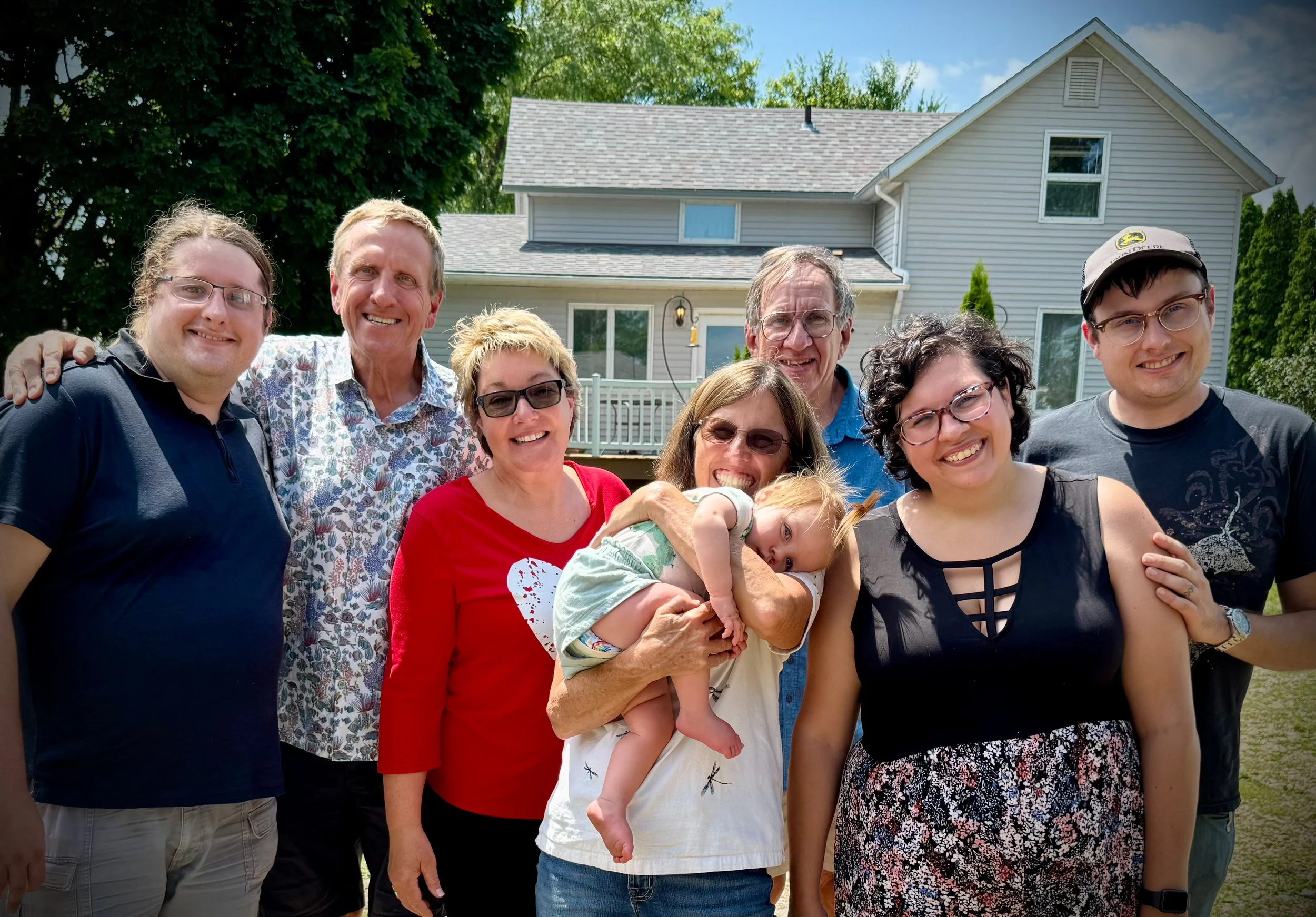 Eric and his family outside of a farmhouse.