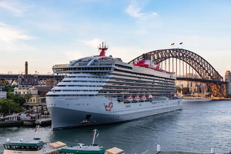 Large cruise ship docked at a harbor near the Sydney Harbour Bridge in Australia.
