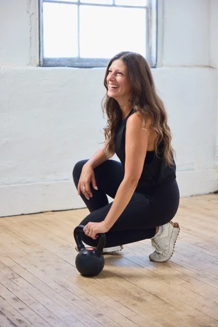 Women holding dumbbell wearing fitness attire.