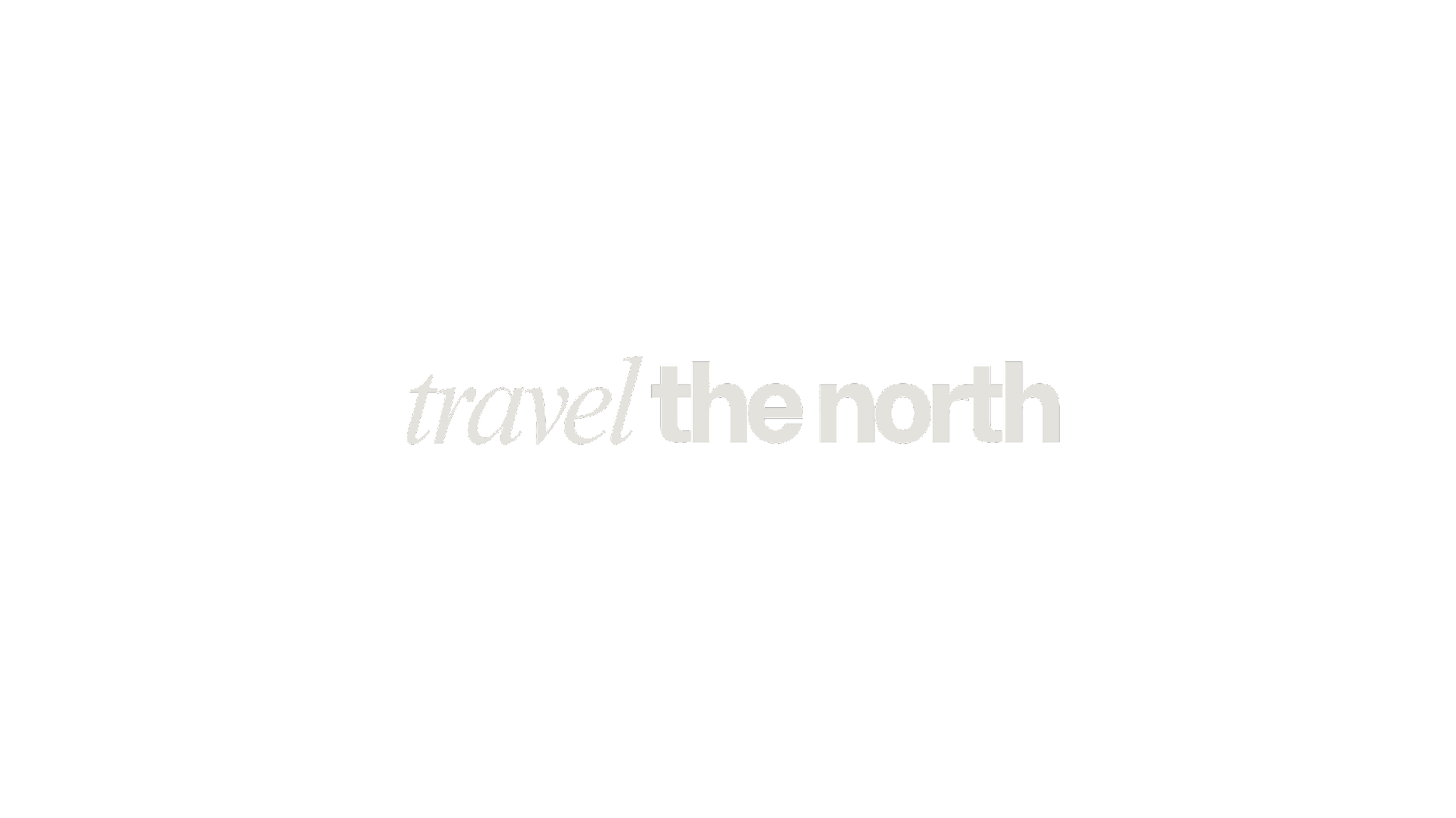 Black background with the words "travel the north" in gray text, with "the north" appearing bolder.