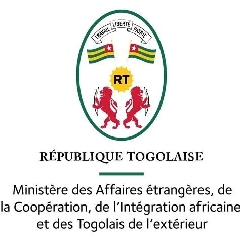 Emblem of the Togolese Republic featuring a shield with the national motto, two lions, and flags, along with French text indicating it's from the Ministry of Foreign Affairs.