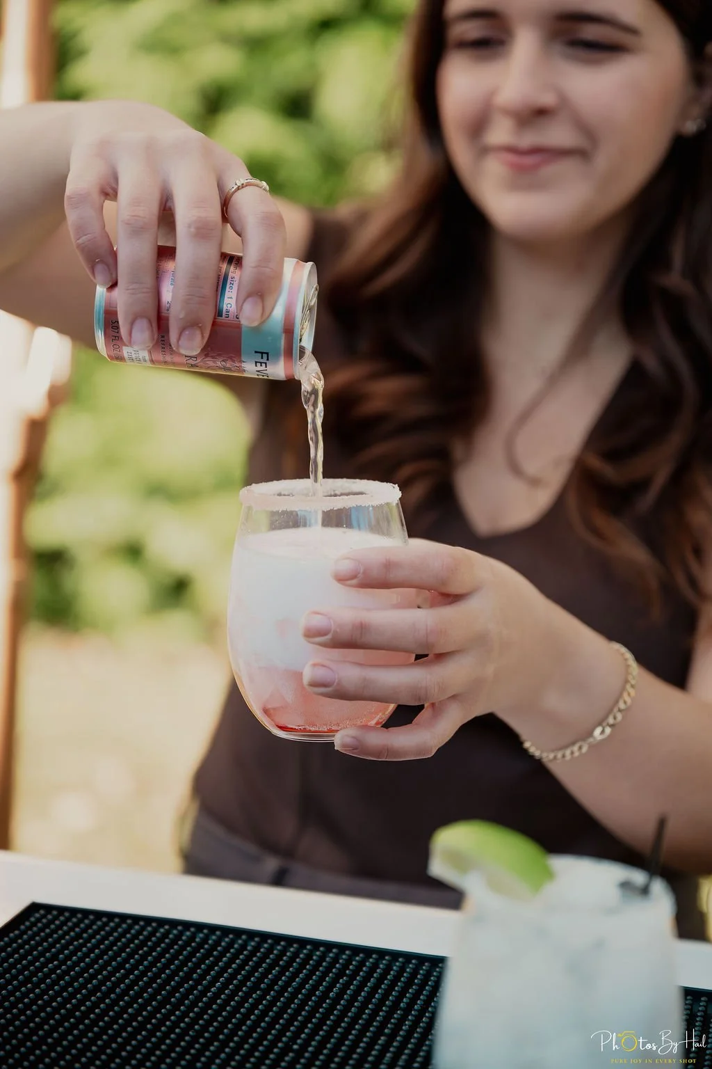the owner, Cara, pouring a can of grapefruit juice into a wine glass