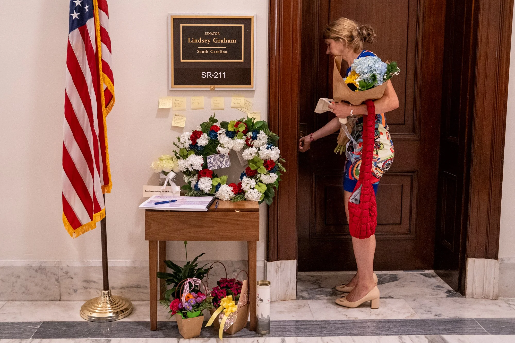 A passerby pays their respects to the late Lindsey Graham (R-S.C.) in front of his office at the Russell Office Building in Washington, D.C., on Monday, July 13, 2026.