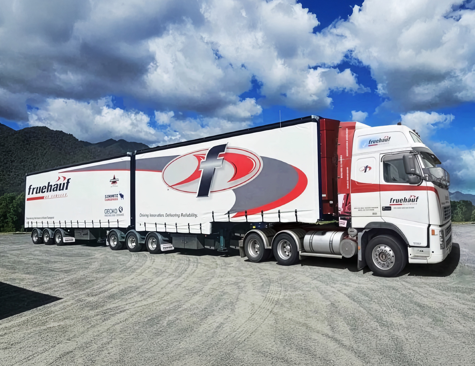 Fruehauf branded curtainsider trailer, parked under a bright blue sky