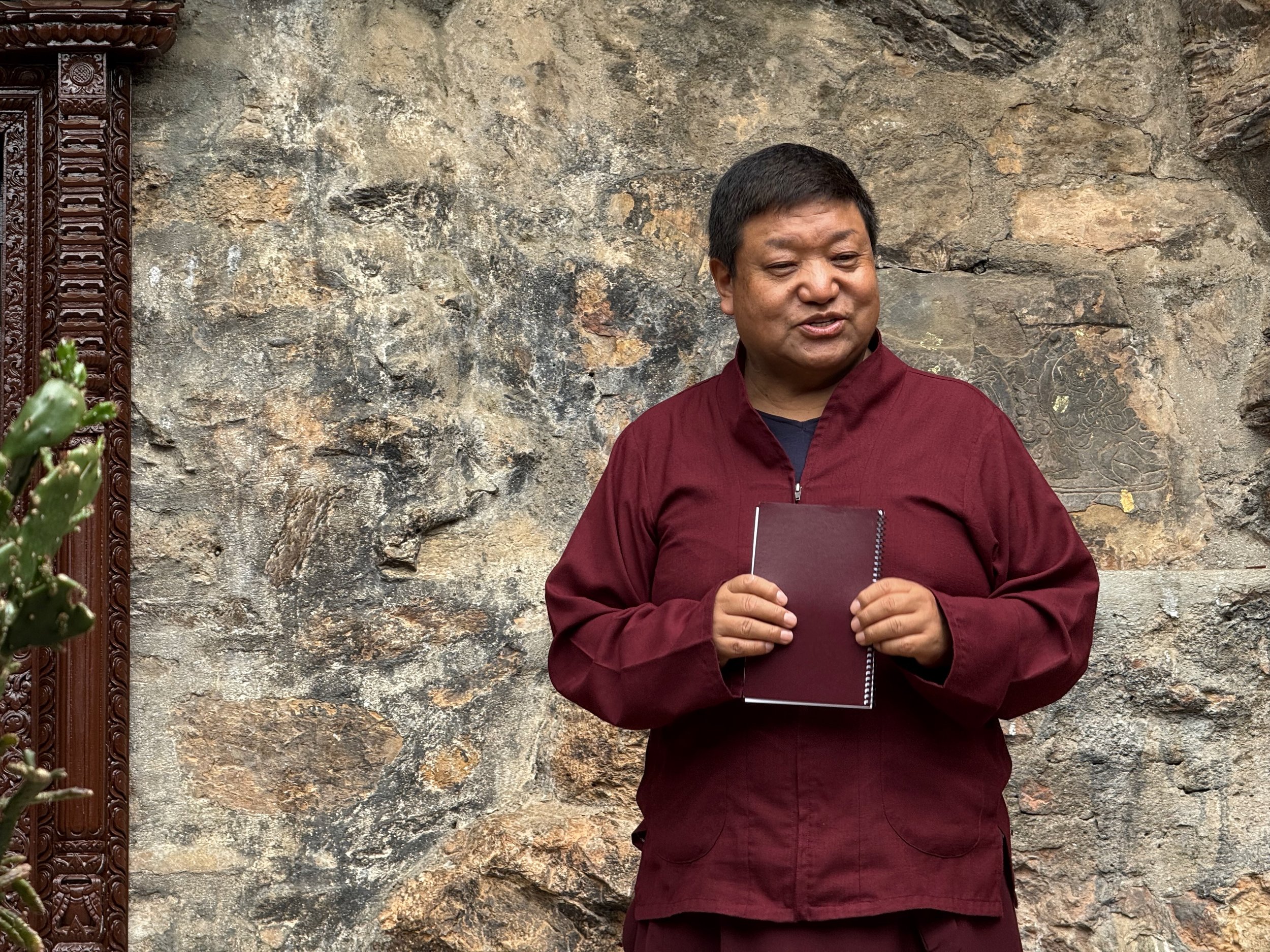 Orgyen Chowang Rinpoche giving talk near famous cave entrance in Bhutan.