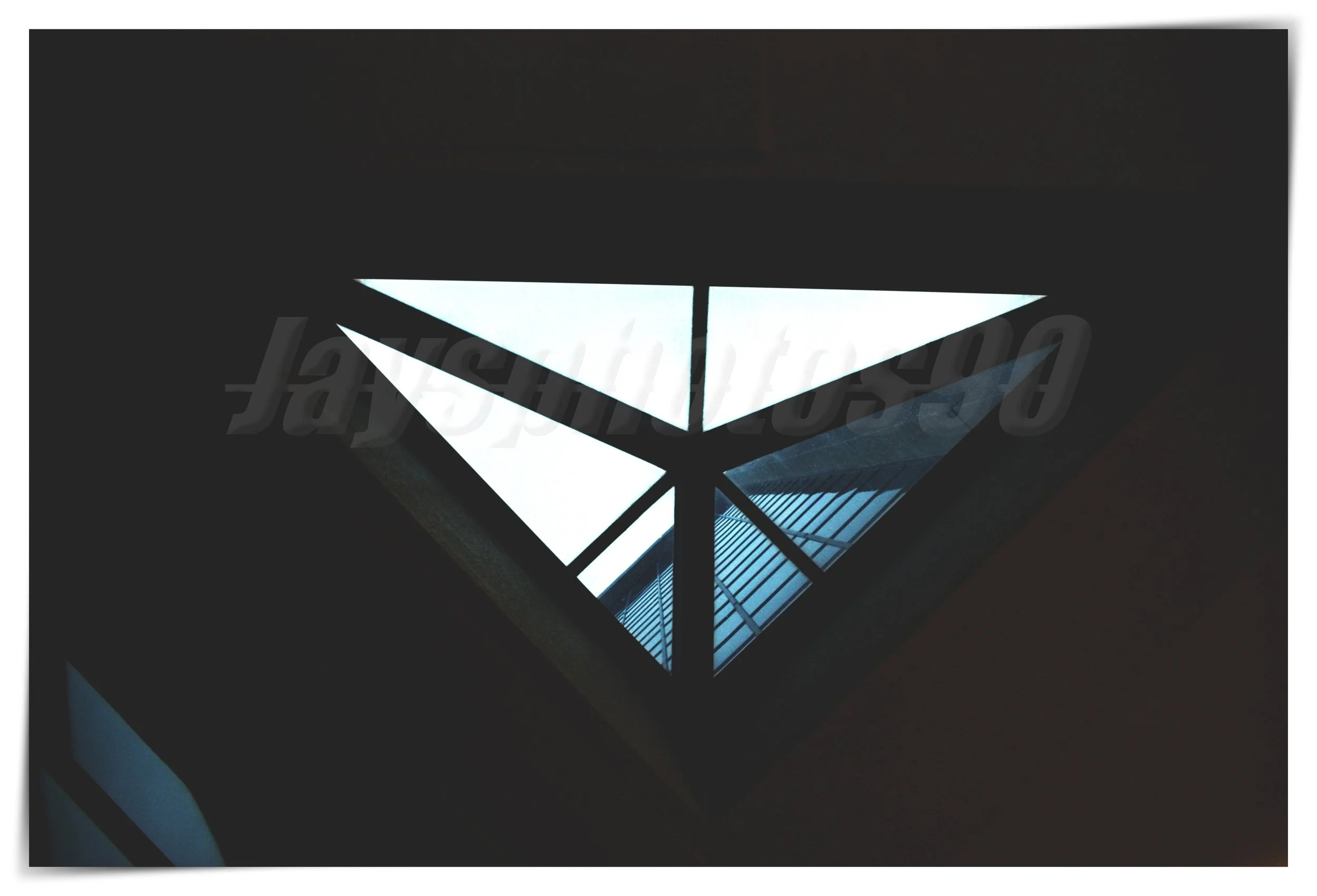A geometric patterned ceiling design with illuminated white and blue sections, viewed from below.