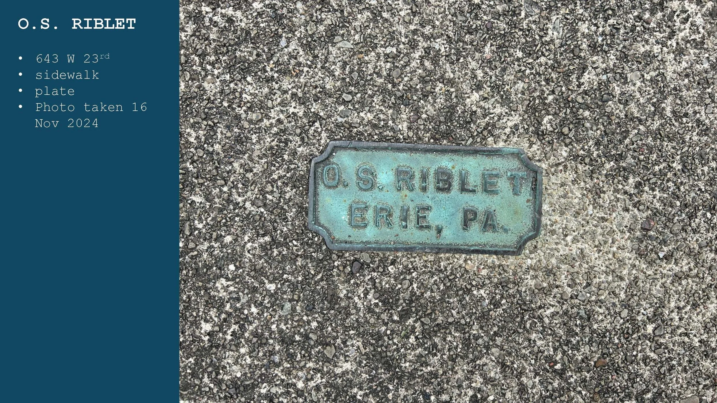 A rectangular metal plaque embedded in asphalt sidewalk, inscribed with 'O.S. RIBLET ERIE, PA', with a weathered and greenish patina.