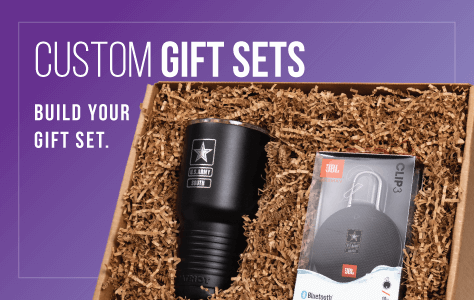 Custom gift set including a black flashlight and a JBL Clip 4 Bluetooth speaker in a gift box filled with brown crinkle paper.