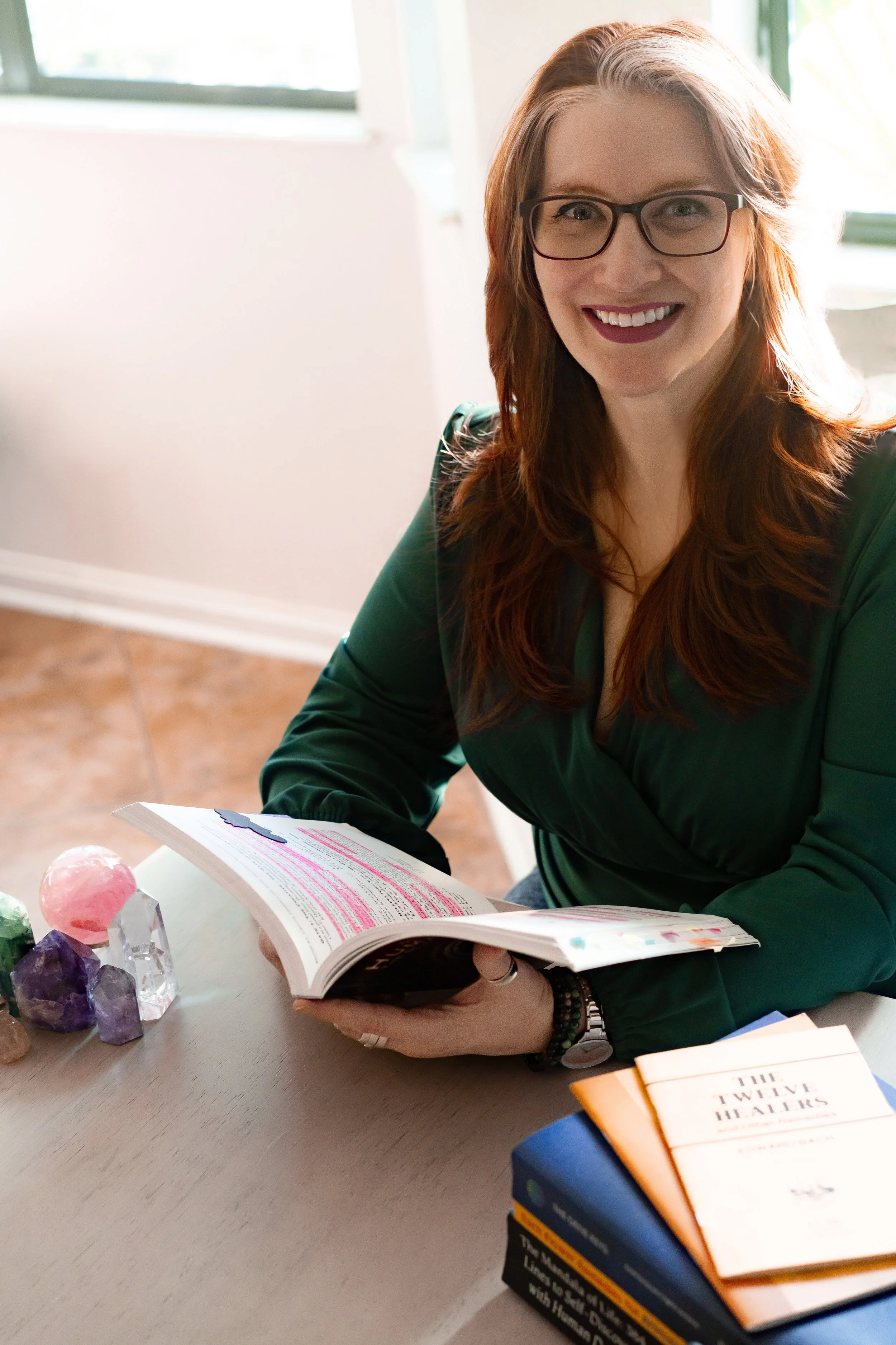 An intuitive healer studying human design charts at a table.