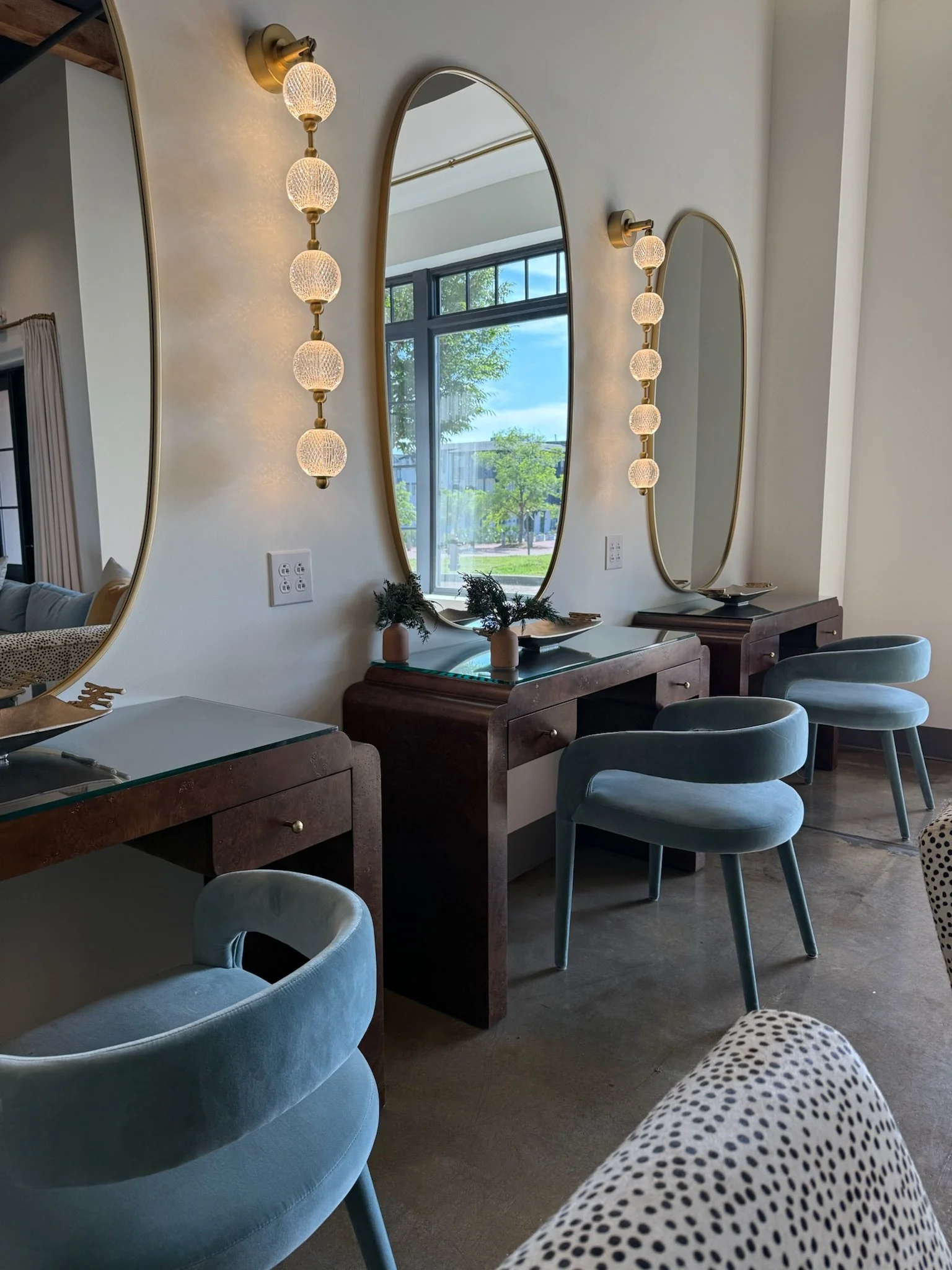 Vanity stations at The Velveteen wedding venue in Madison, MS, with oval mirrors and bead-string pendant lighting for bridal party prep.