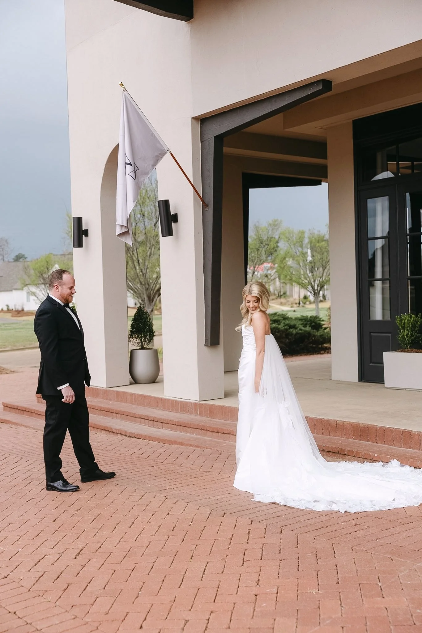 Bride and groom portrait at The Velveteen wedding venue in Madison, MS, sharing a smile outside the entrance of the venue building