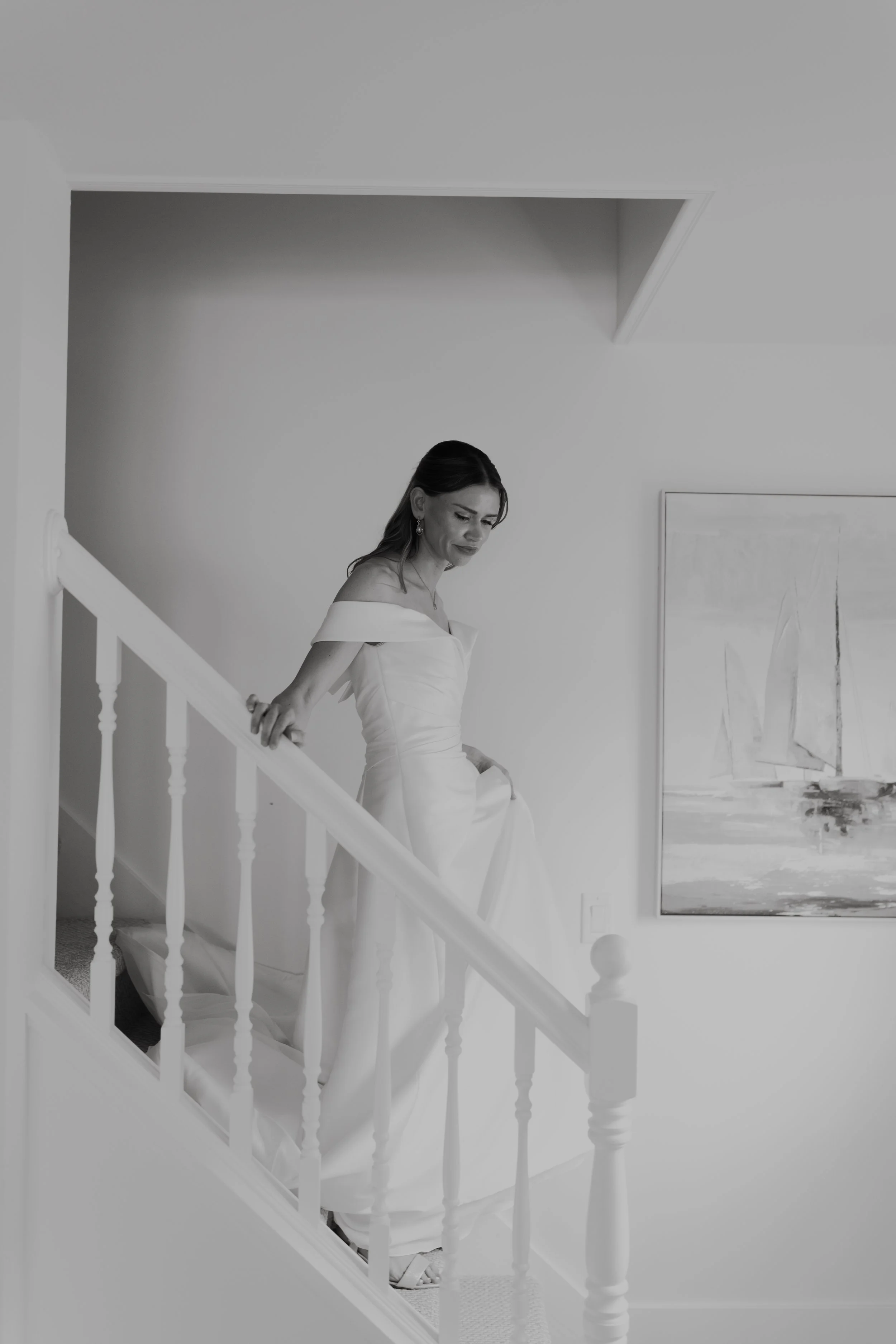 A woman in an elegant wedding dress standing on a staircase.