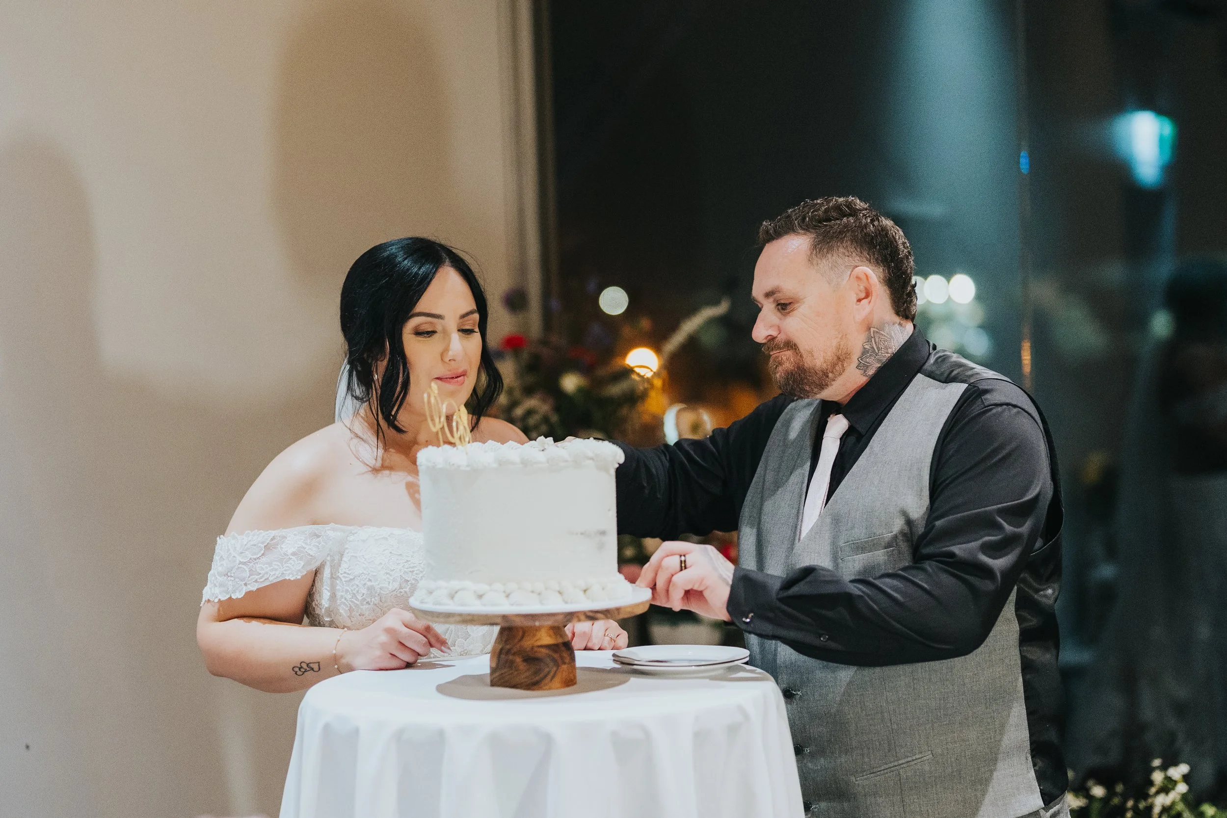 Bride and groom cutting wedding cake at reception.