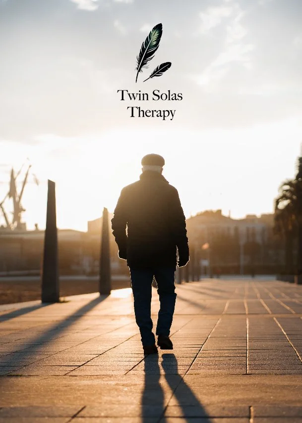 A person walking on a paved pathway during sunset with the logo 'Twin Solas Therapy' and feathers above it.
