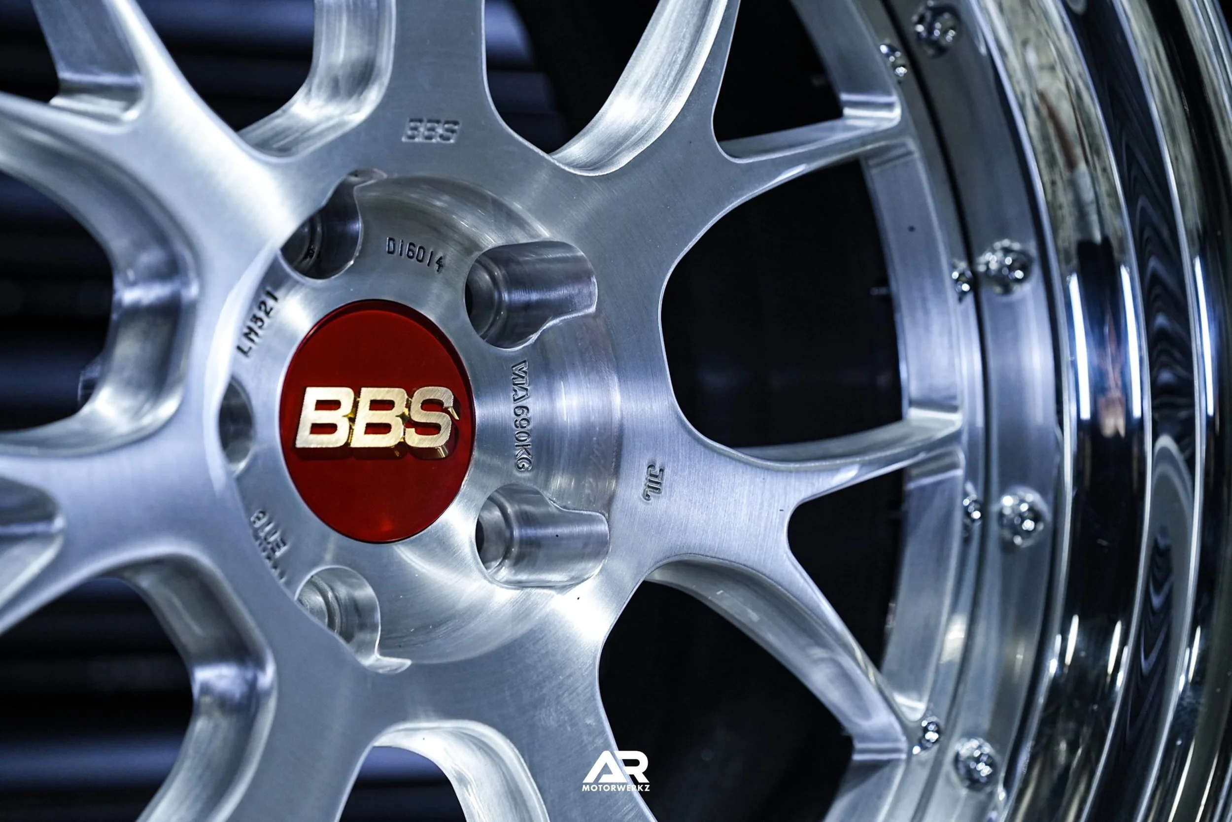 Close-up of a polished silver BBS forged alloy wheel featuring a multi-spoke design and signature red center cap, representing premium custom wheel fitment for high-end vehicles