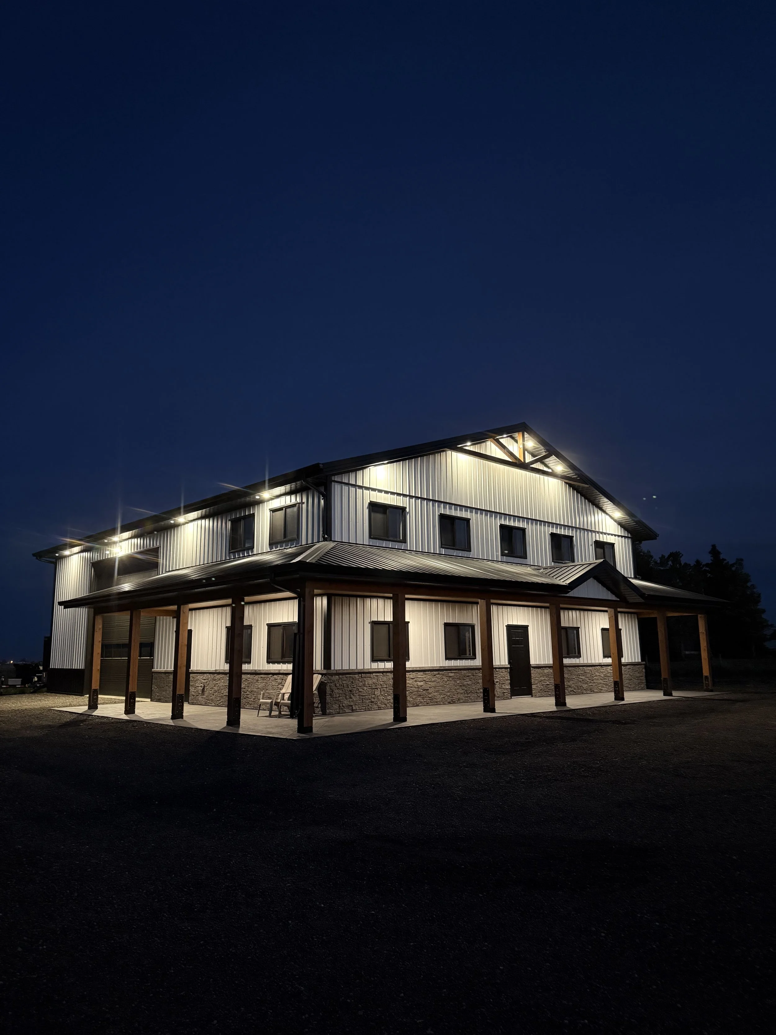 Post frame building underway in Southern Alberta. This project shows the full structural framework during construction, with engineered trusses, precise spacing, and heavy-duty equipment on site. Our team is preparing this large agricultural shop for