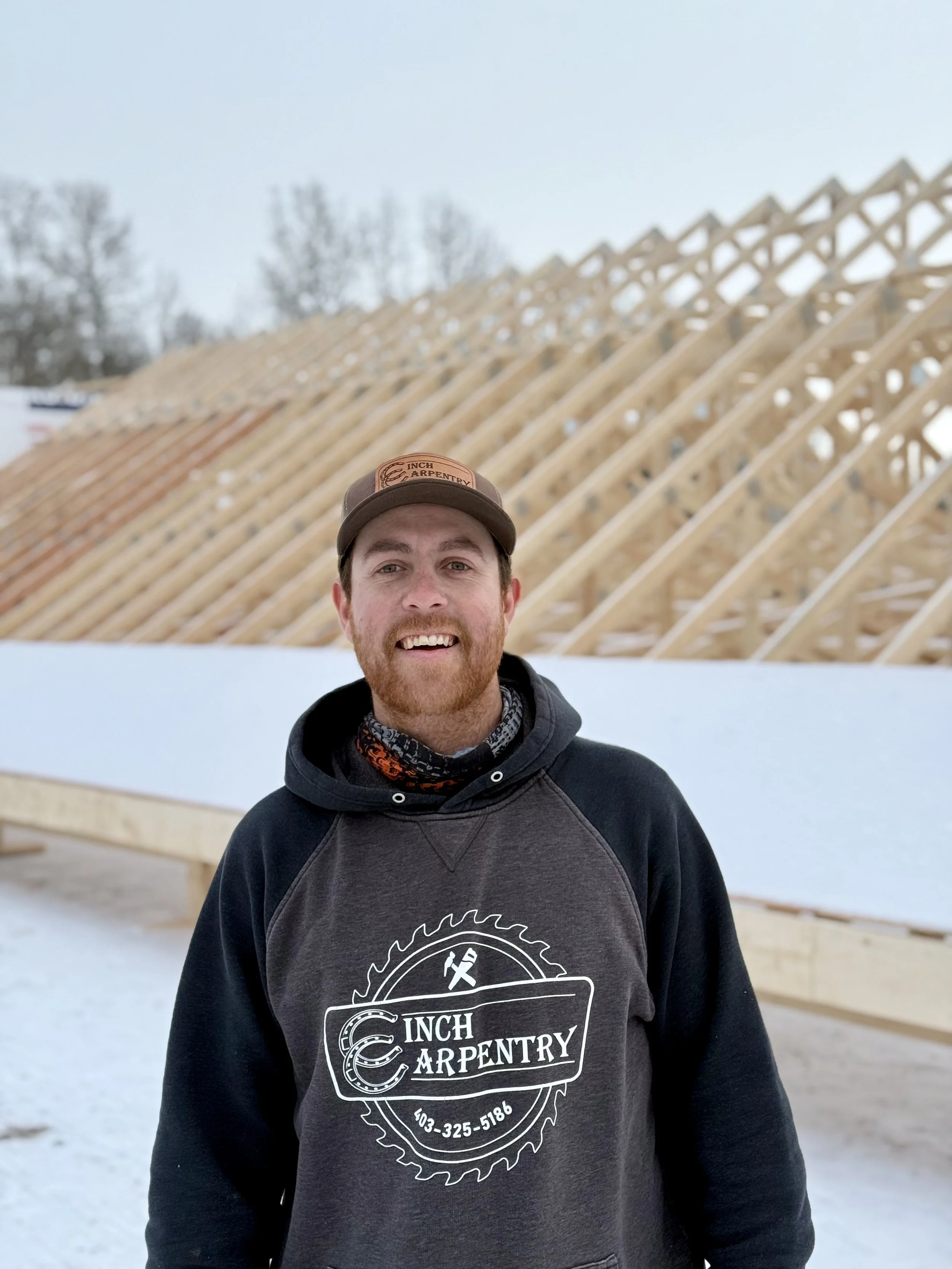 Five young men standing together on a stage, smiling with some holding tools like hammers. The stage background is made of wood with colorful lights overhead and a hashtag '#HITZHATCHETS' projected on the top. They appear to be participating in an activity or event related to using hammers.
