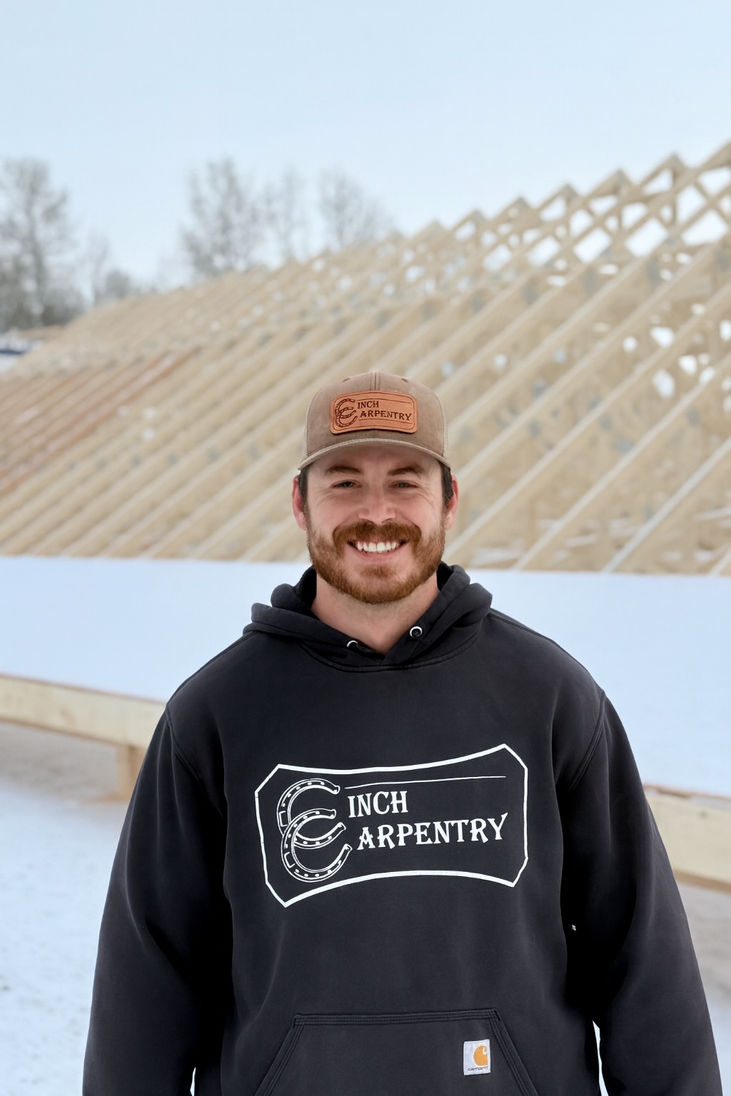 Five men standing together in a laser tag arena, smiling and holding laser tag guns. They are wearing casual clothing and hats, with a dark background adorned with colorful string lights, and a sign that reads #HITZHATCHETS at the top.