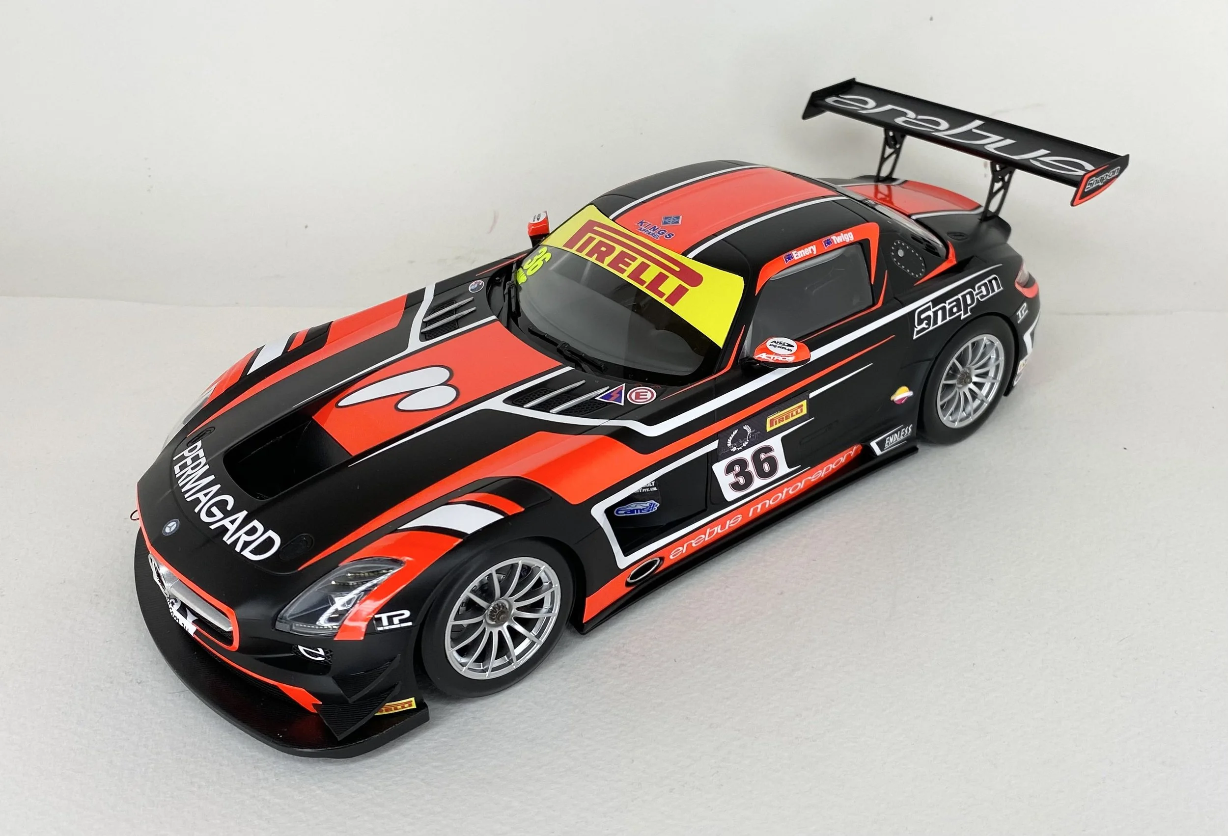 A detailed model of a race car with black, red, and white graphics, various sponsor logos, and the number 36 on its side.