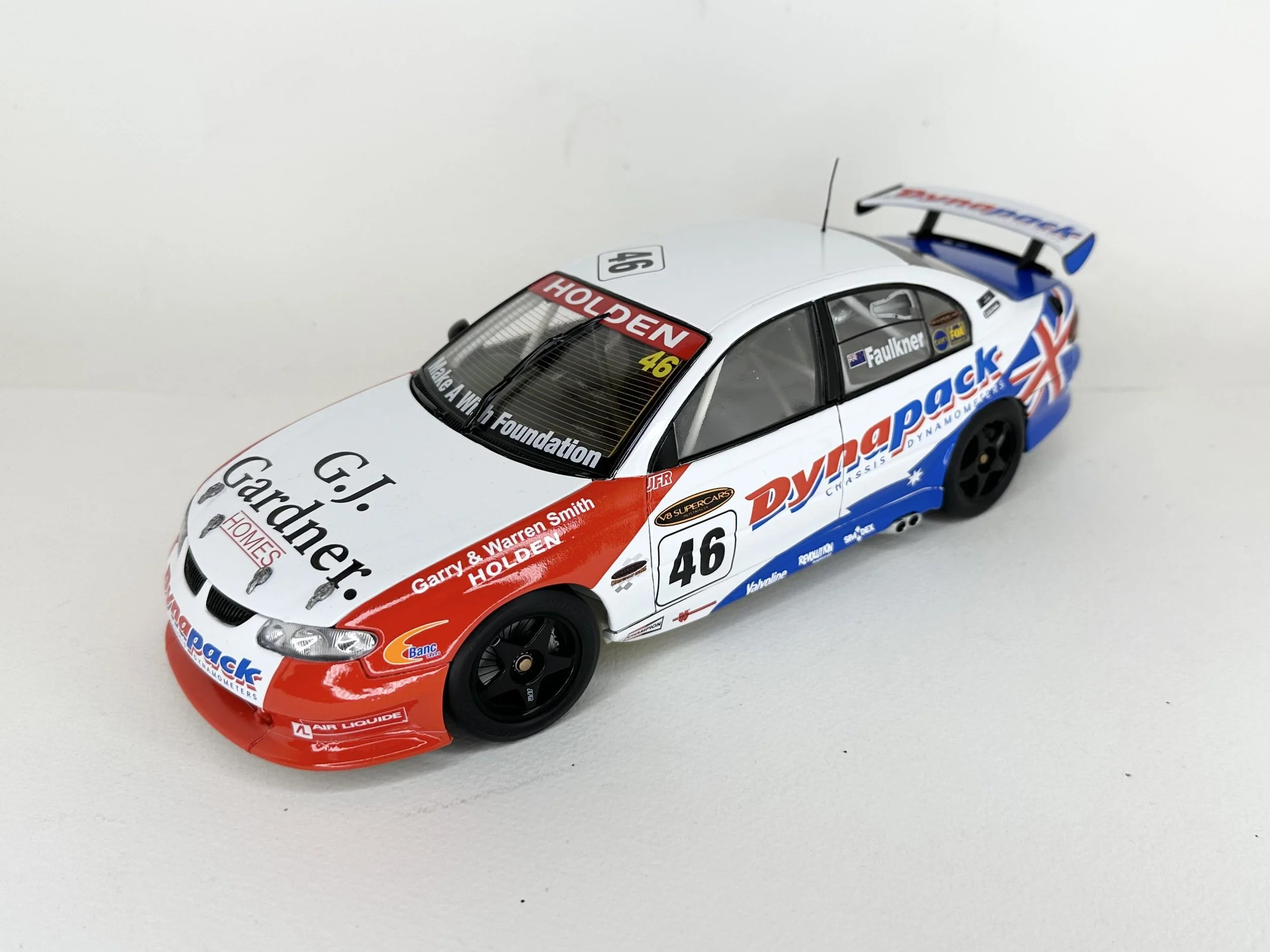 Model race car with sponsor decals, the number 46, and a rear spoiler on a white background.