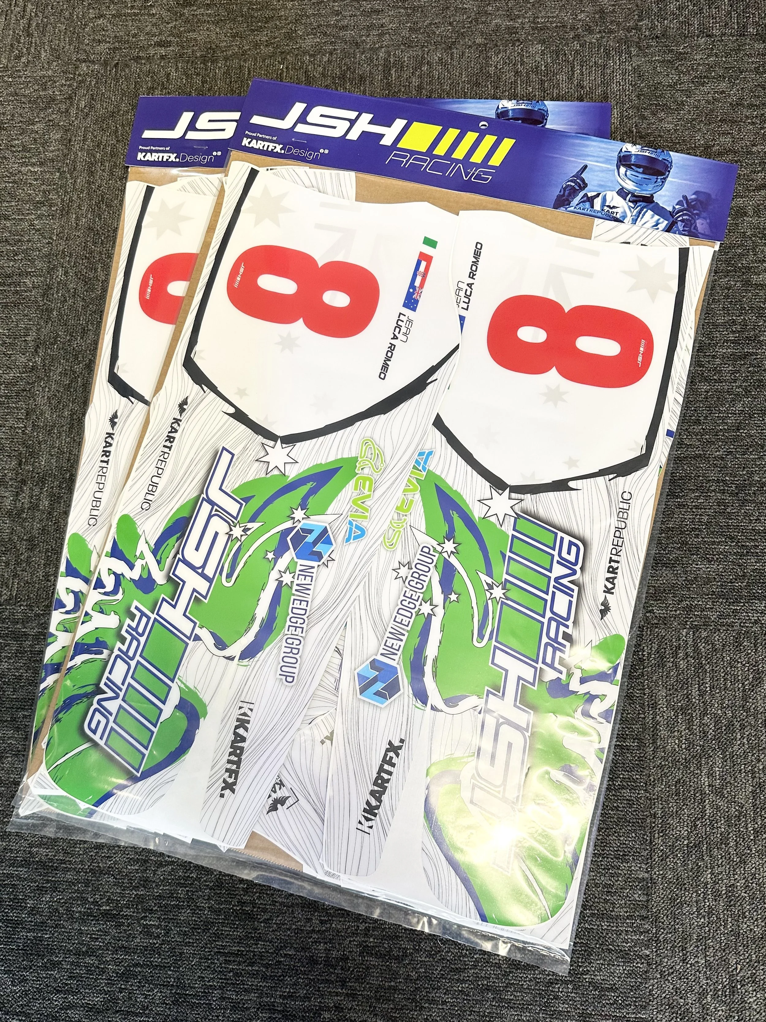 A package of kart racing decals including large numbers, logos, and designs in green, white, blue, and black colors, with racing-themed illustrations.