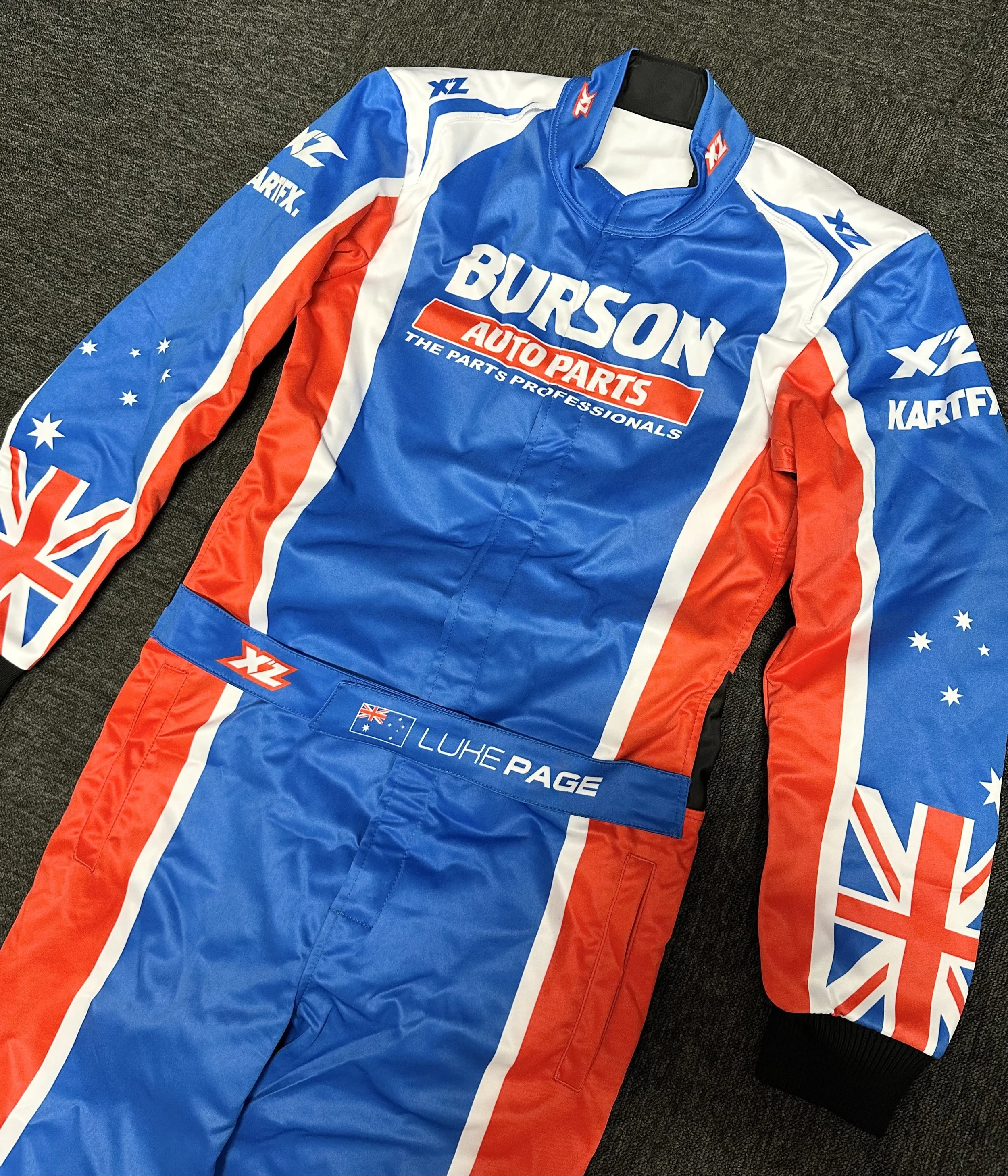 A racing suit with blue, red, and white colors featuring Australian flag designs and sponsor logos, including "Burson Auto Parts" and "Luhé Page."
