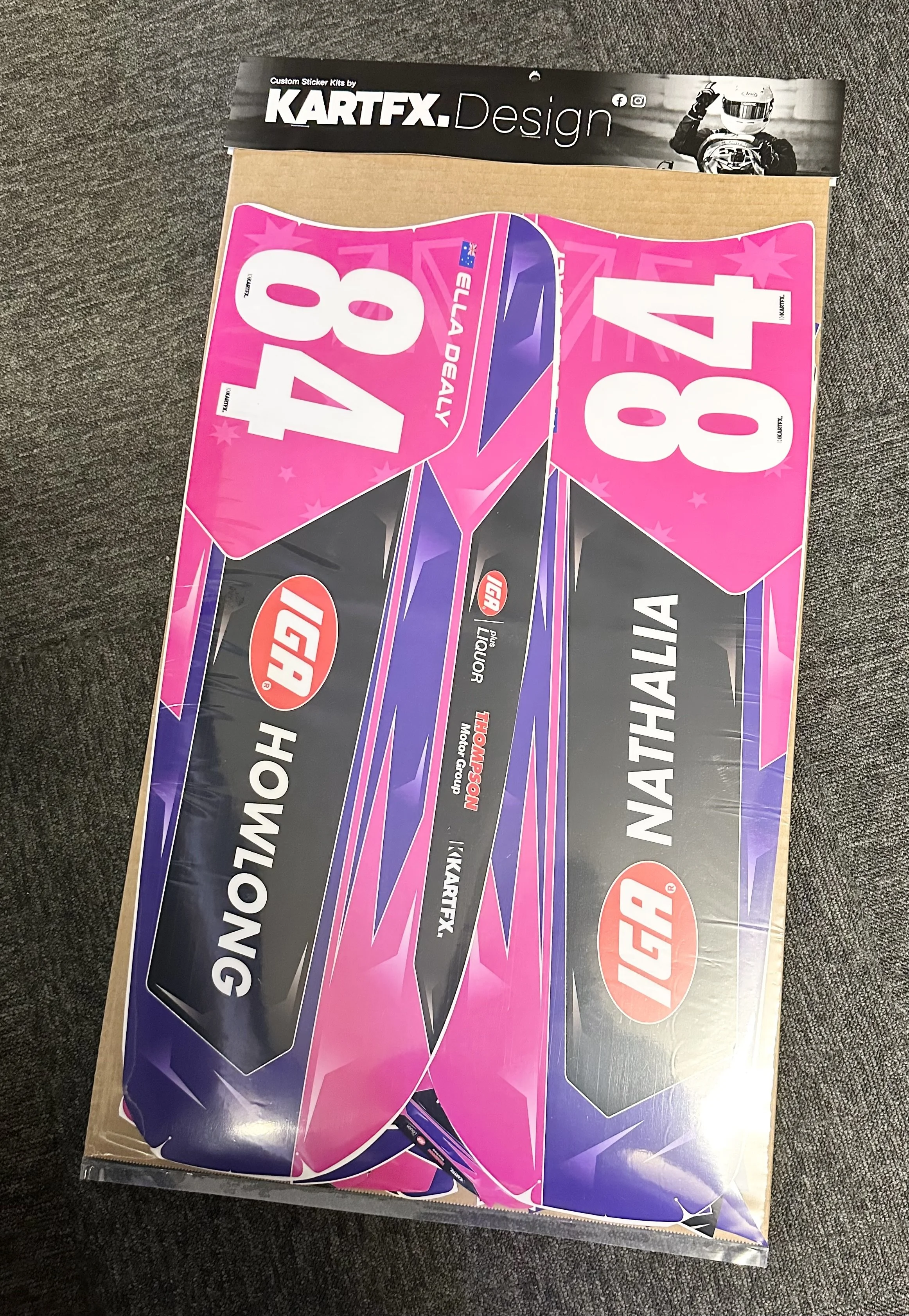 Colorful decal sheet for a race car with pink, purple, black, and white graphics, featuring the name 'NATHALIA' and the number 84; branded with 'KARTFX' and other racing sponsors.