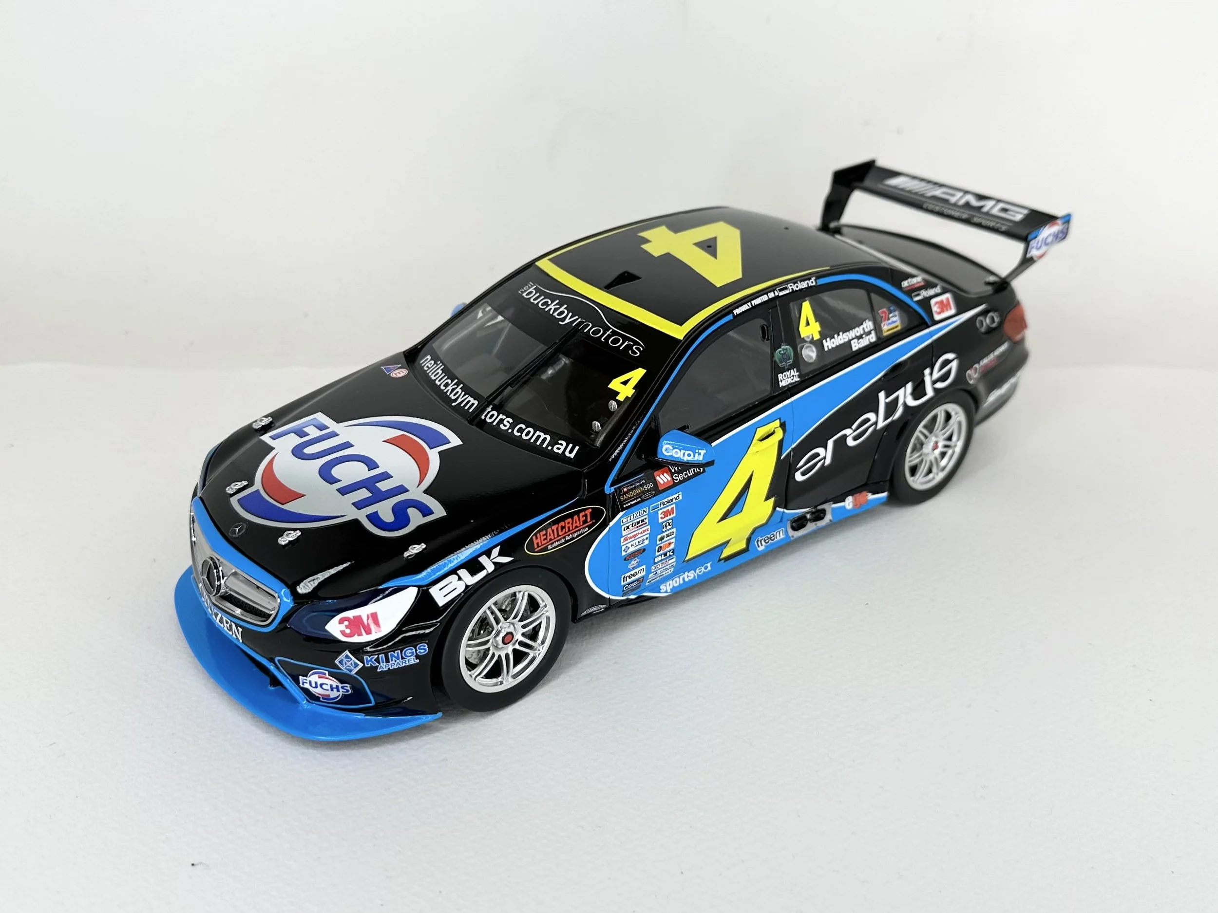 Black and blue model race car with sponsorship logos and the number 4, positioned on a white background.