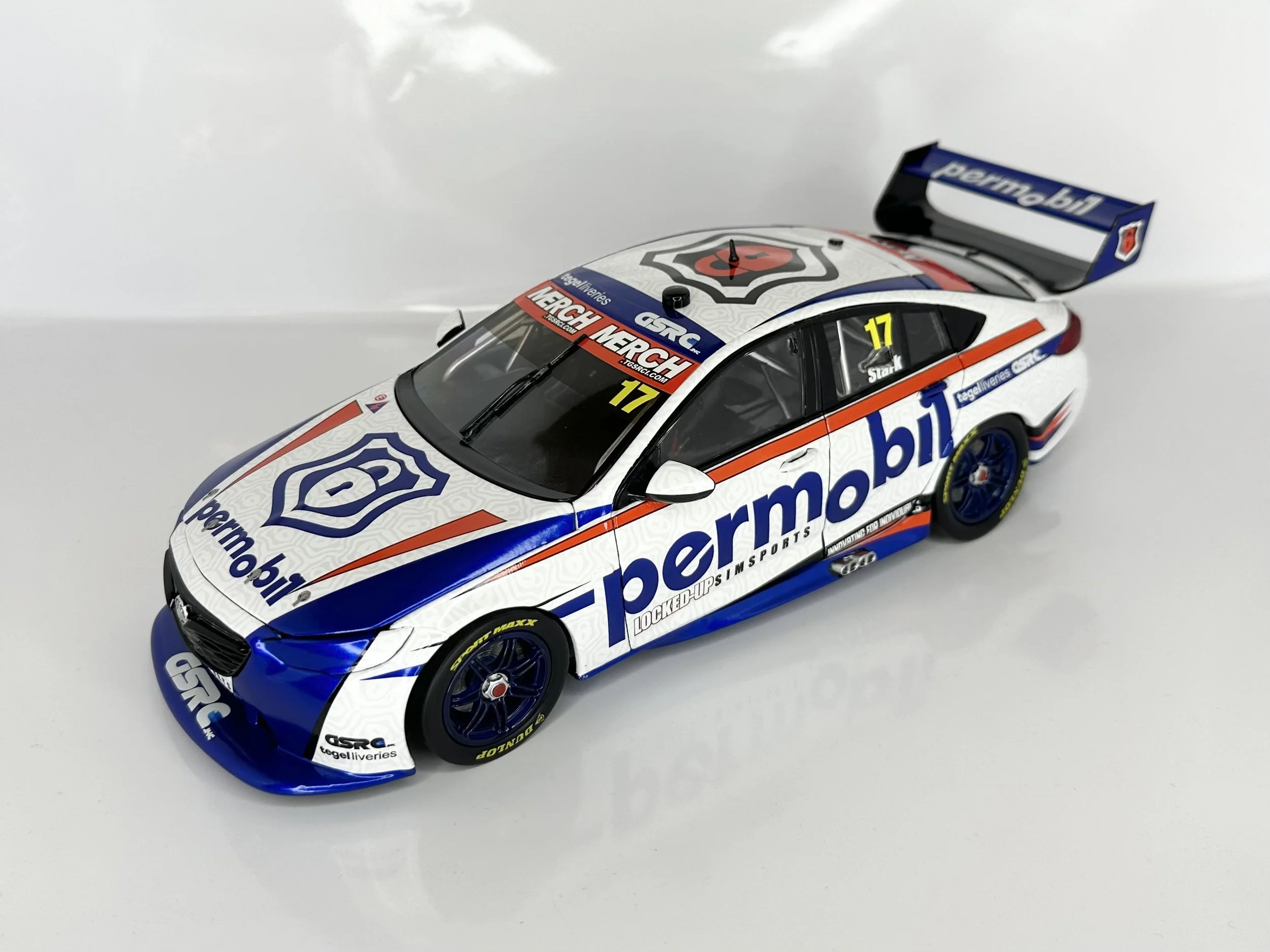 A detailed scale model of a race car with distinctive Mobil branding and sponsor logos, featuring a blue, white, and red color scheme, racing number 17, and a rear wing.