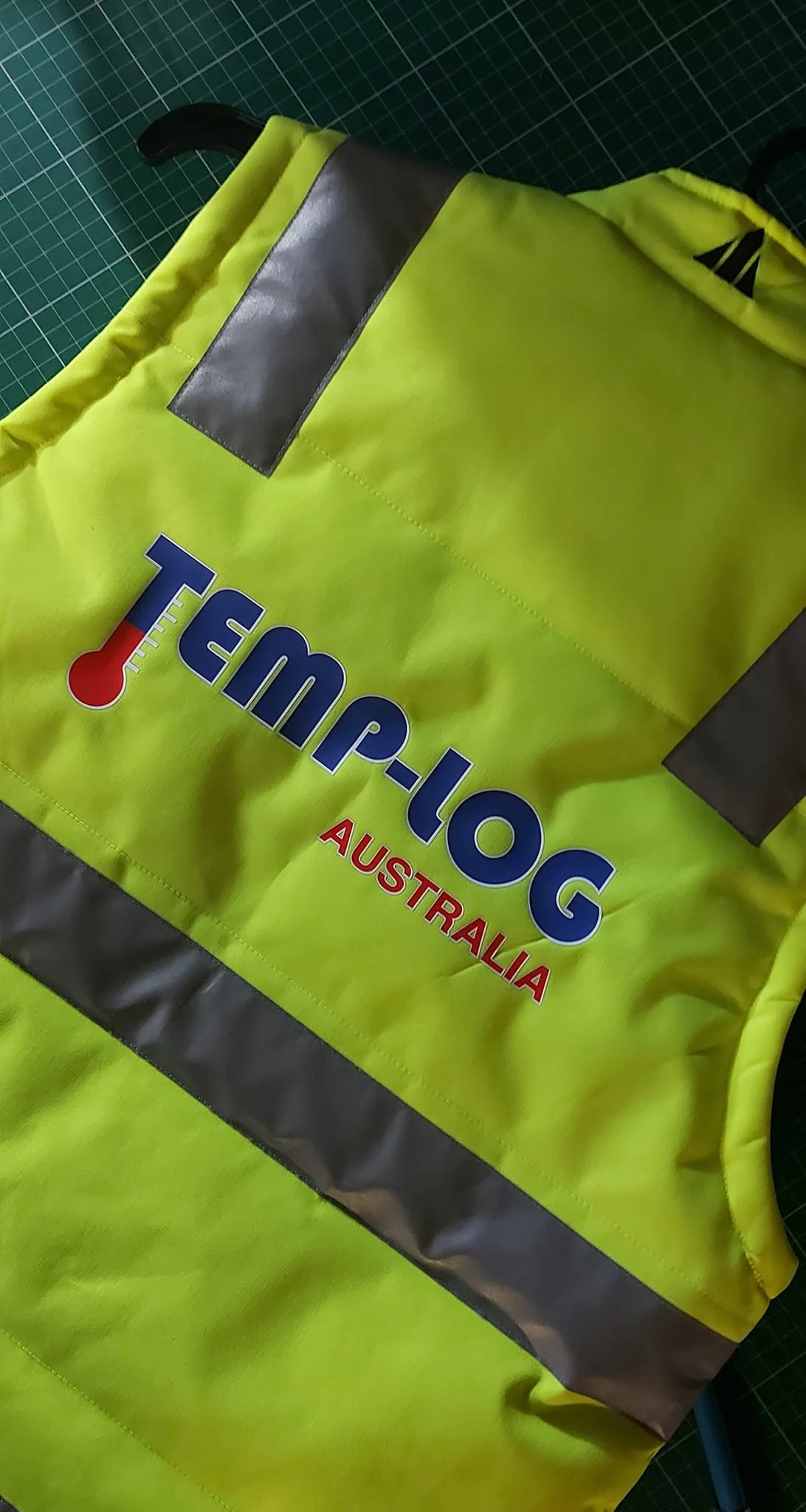 A high-visibility yellow safety vest with reflective gray strips and the logo 'TotalTool Australia' on the front.