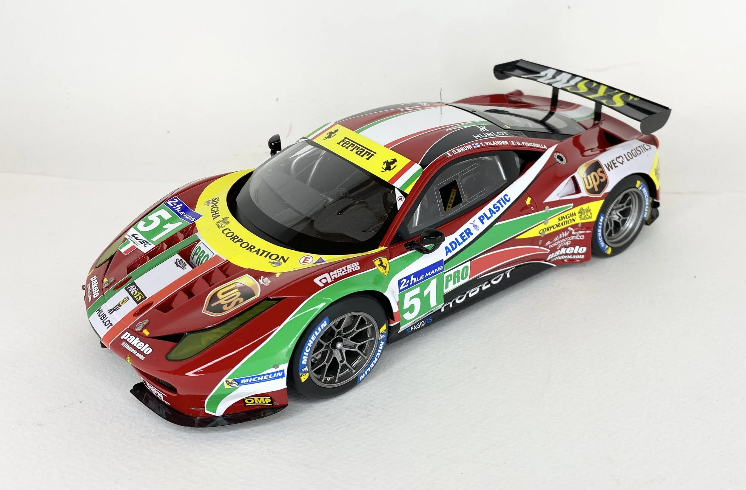 Detailed scale model of a Ferrari race car with sponsor decals and racing number 51, featuring a rear spoiler and aerodynamic design.