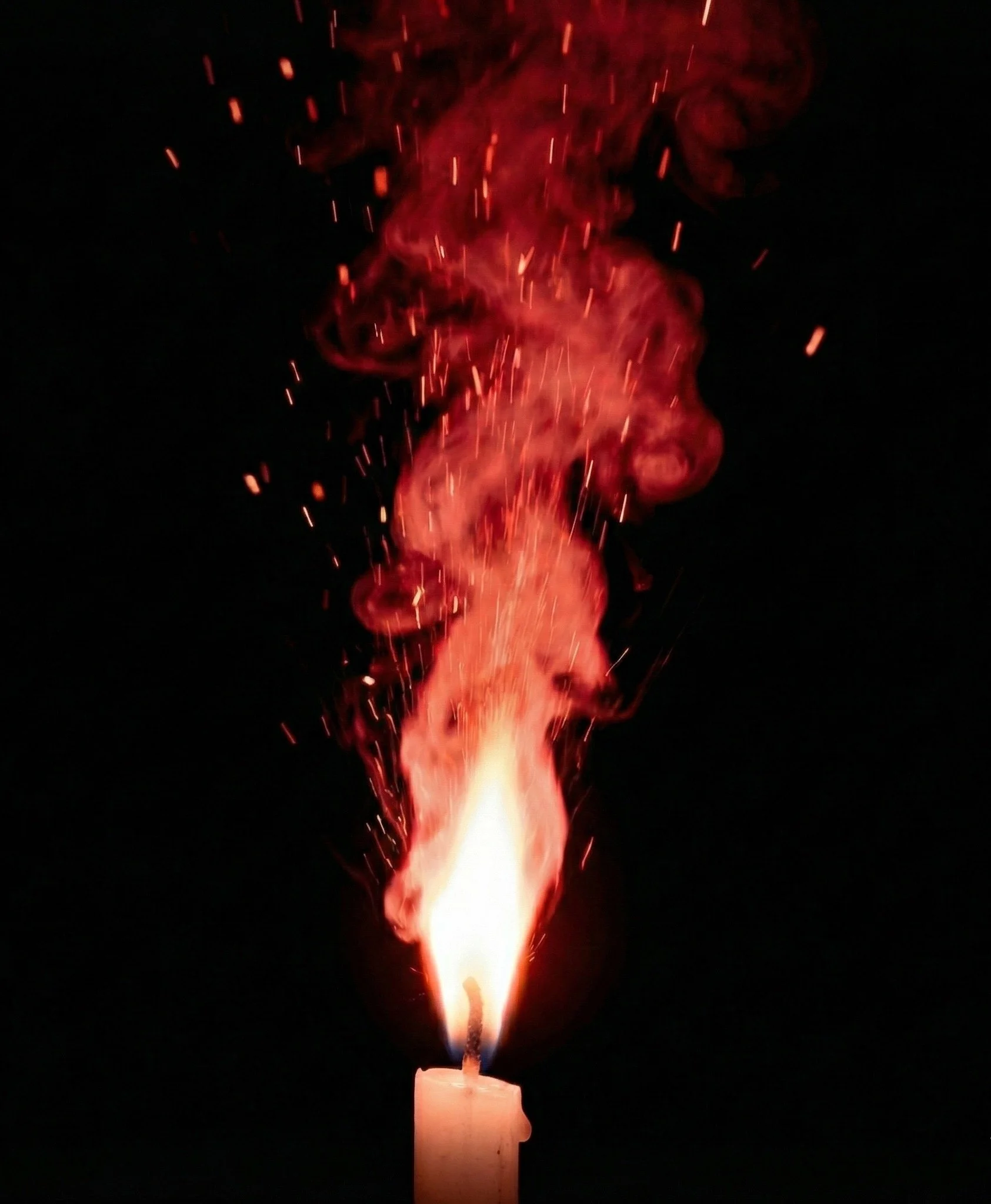 Candle, with vivid flame rising with red smoke and scattered sparks against black background, symbolising Accendo Marketing's digital marketing services that build sustained visibility for recruitment firms