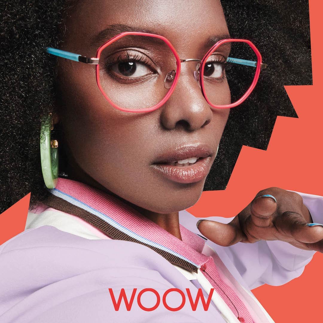 Close-up of a woman with curly hair wearing pink WOW glasses, available at Torquay Eyecare.