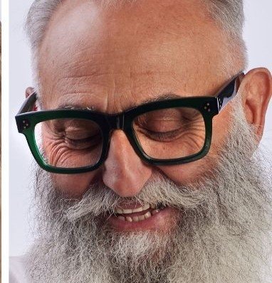 Close-up of smiling older man with gray beard and glasses available from Torquay Eyecare.