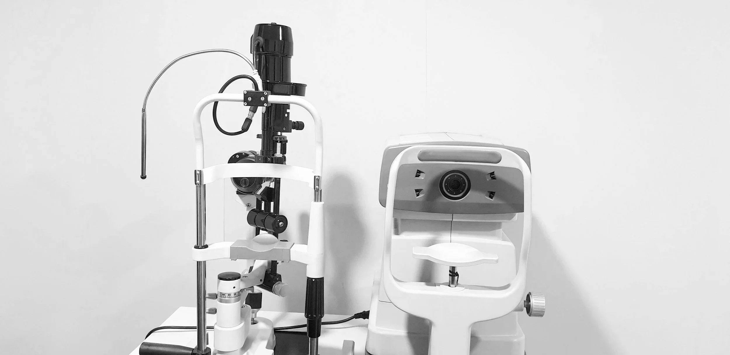 Medical equipment including an eye examination machine and a chair in a clinical setting.