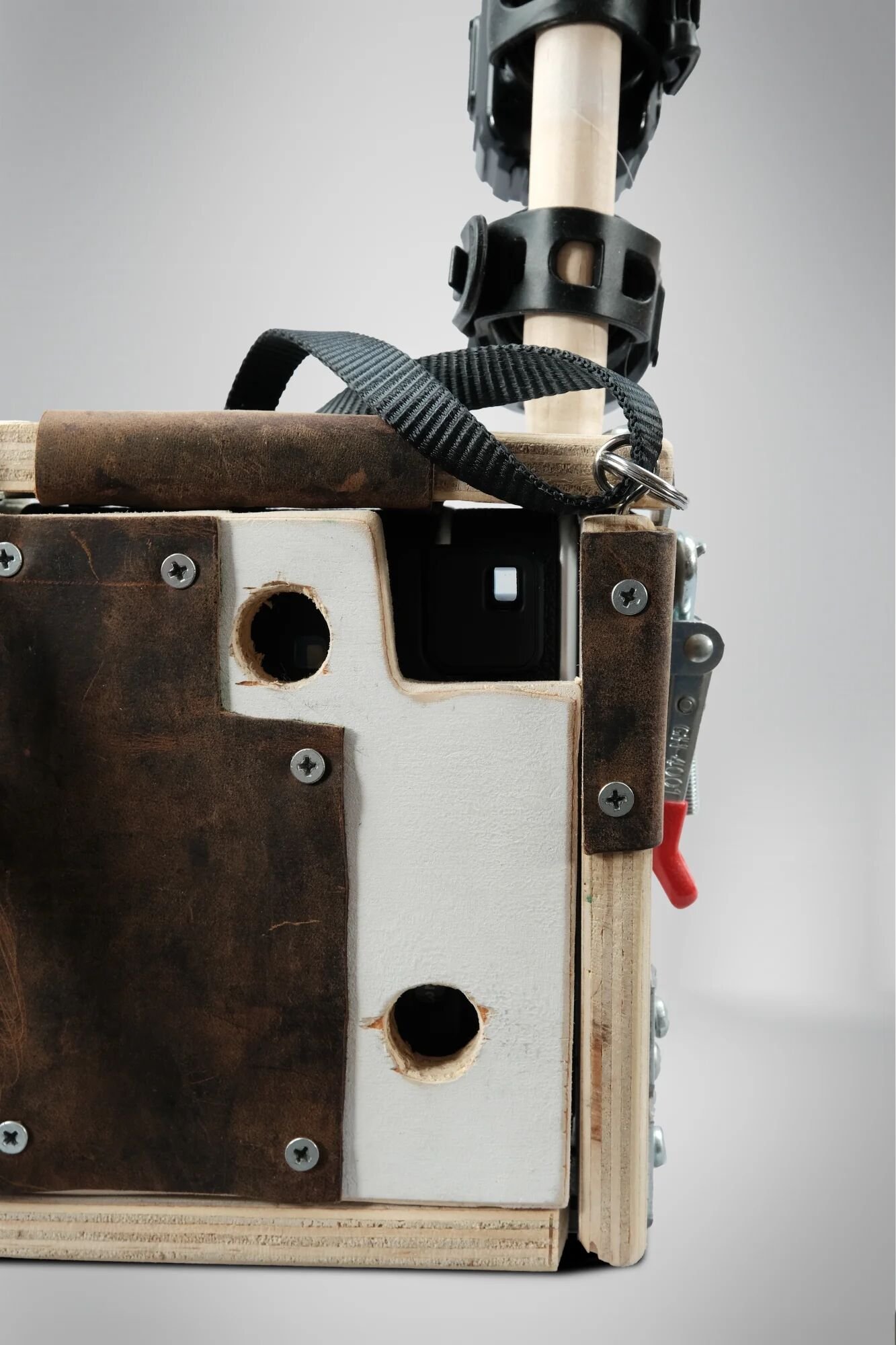 Back housing showing viewfinder holes enabling sight through camera whilst enclosed. Circular cutouts position film counter visibility, vertical spacing ensures instant photo ejects from top. Functional access designed into bricolage housing—precise 