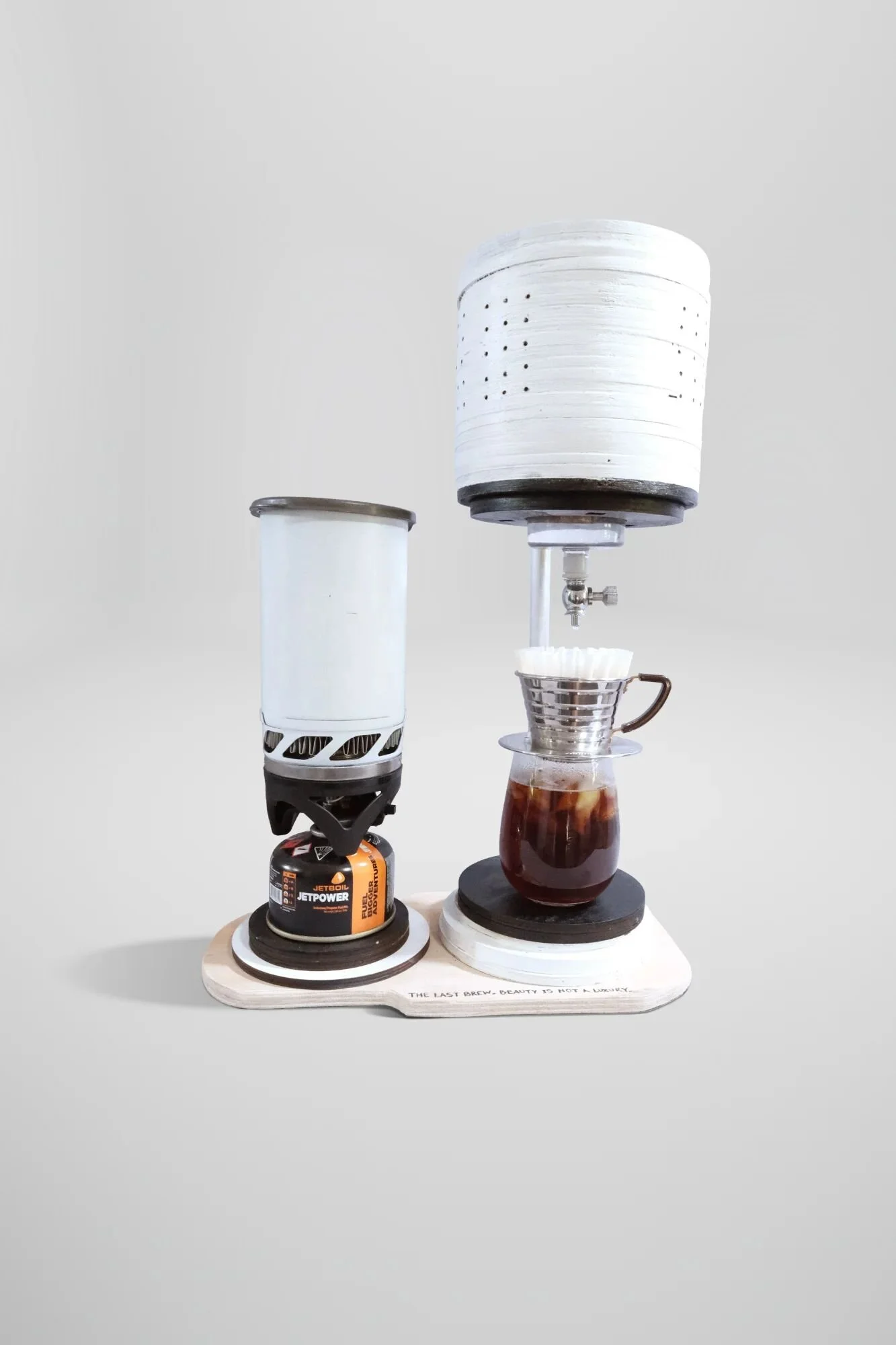 Actually brews coffee. Laminated laser-cut wood cylinder, stainless steel dripper, borosilicate glass, modified Jetboil Zip. Proportions maintain KF20 Aeromaster (1972) functional relationships through material translation. When you can't waste mater