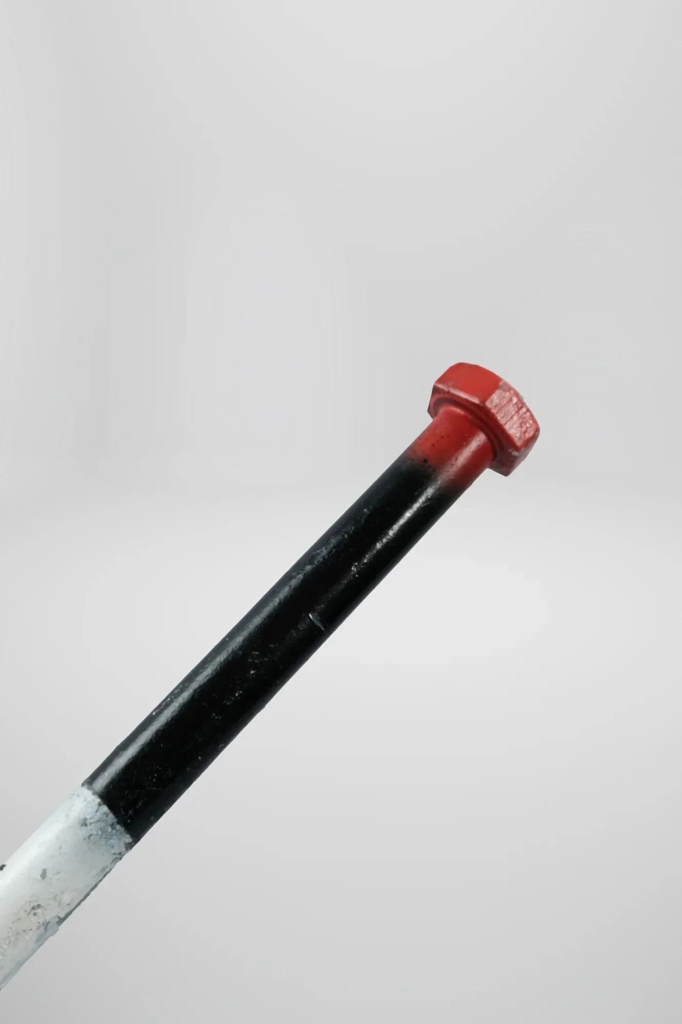 Tri-colour mapping: red tip (danger/ember contact point), black midsection (transition zone), white base (warning inscription area). Looked like a joint. Both crack skulls—club instantly through external violence, joint slowly through internal damage