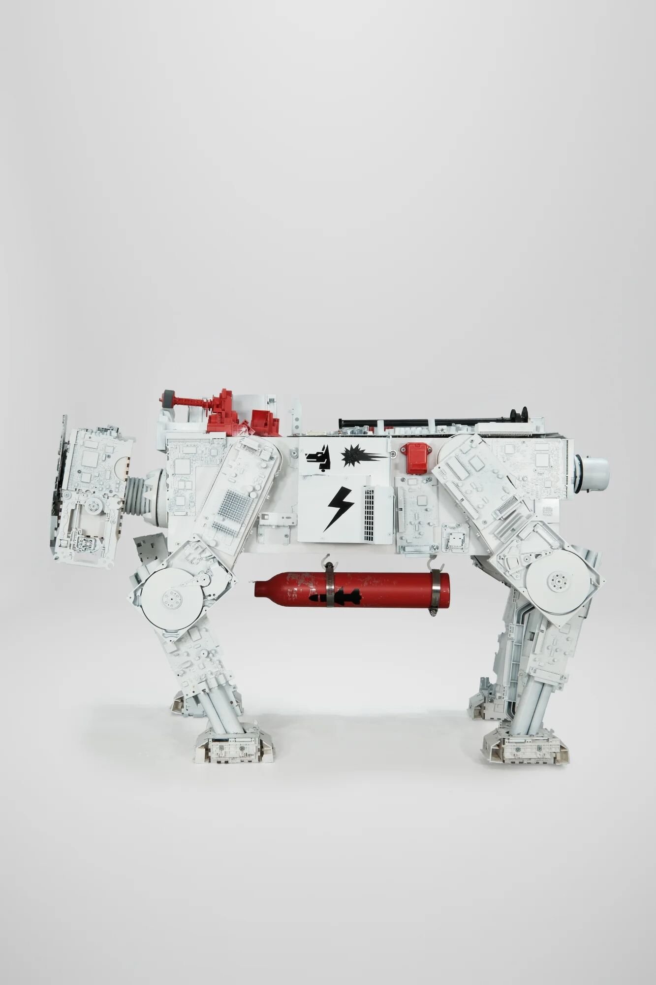 Top-down view revealing body construction. Circuit boards, RAM modules, PC case components visible through white coating. Shock Red cylinder and head mechanism. What watches also corrupts. What touches also spreads. Friday comes weekly