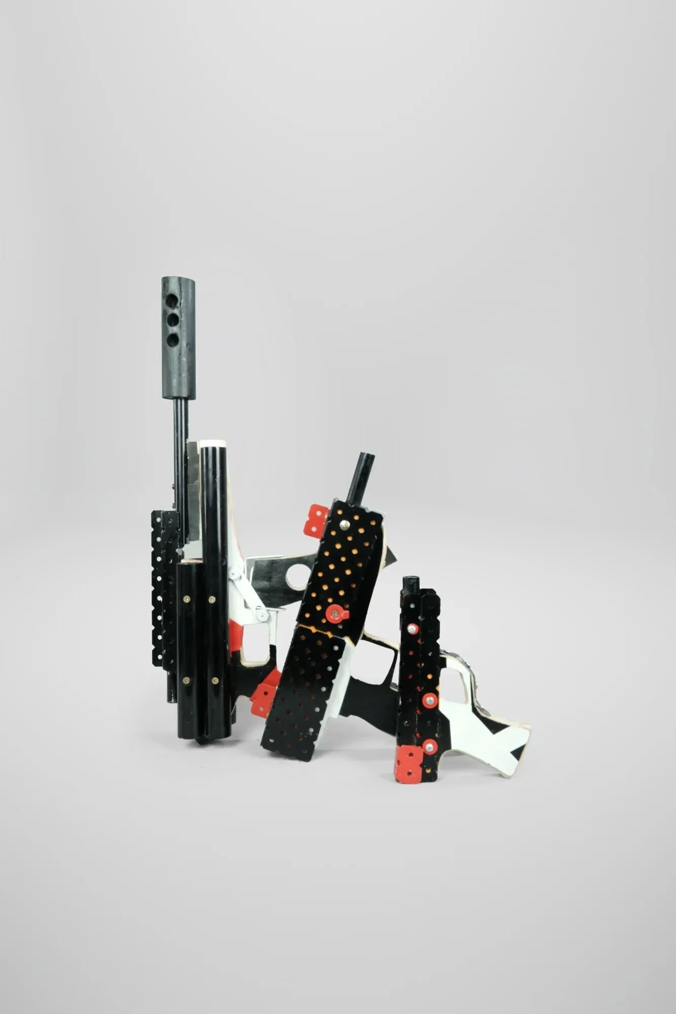 Three weapons built in 10 hours across urgent sessions following August 15, 2024 ranch attack. UZI, MP5, Glock—all precision-constructed, none functional. All lack triggers. The absence is the architecture.