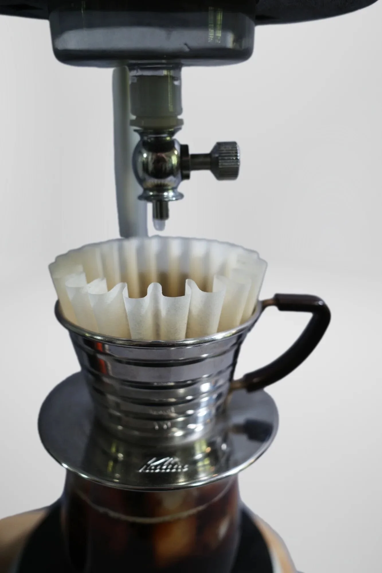 Stainless steel and borosilicate glass dripper, paper filter. Clean material separation—wood provides structure, steel/glass handles water contact and thermal shock. Modified Jetboil Zip system runs safely through complete brewing cycle, wood positio